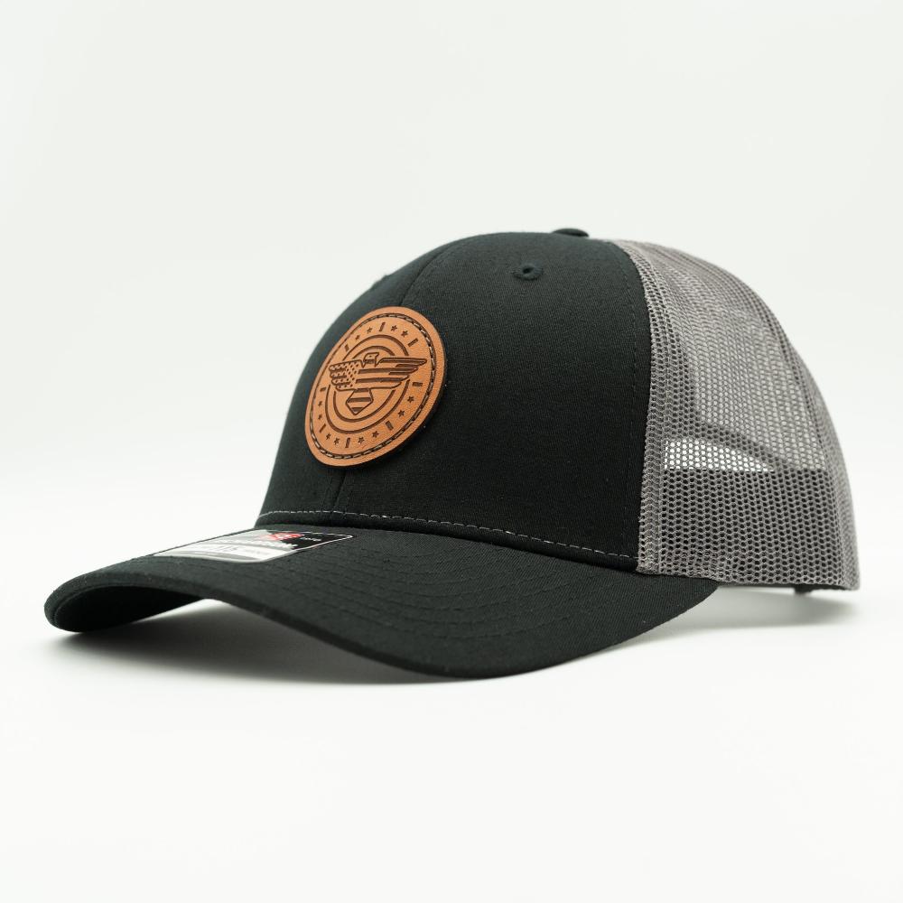 Side view of black and charcoal Richardson 115 low profile trucker hat with American Eagle leather patch, showing black front, curved bill, and charcoal mesh back.
Color: Black/Charcoal