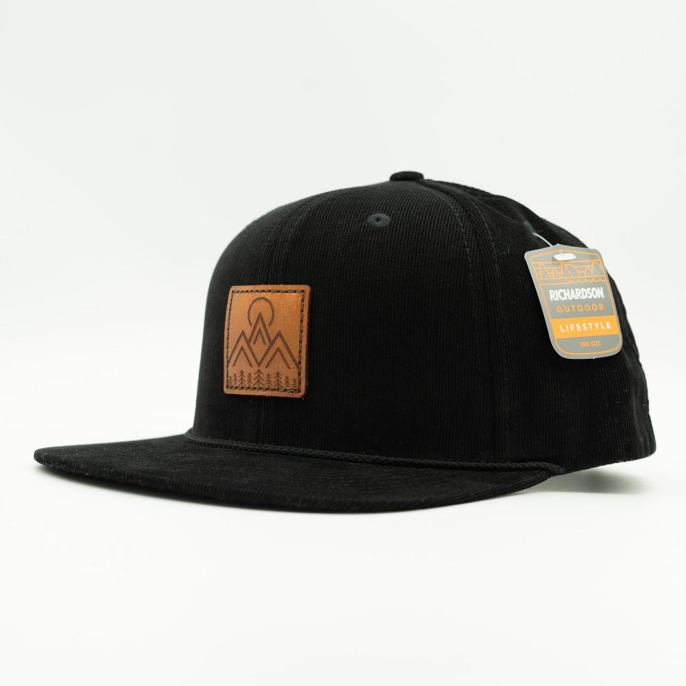 Side view of black Richardson 253 Moonlite Mountain corduroy rope hat, showing the stitched leather mountain patch, flat bill, and structured high crown.