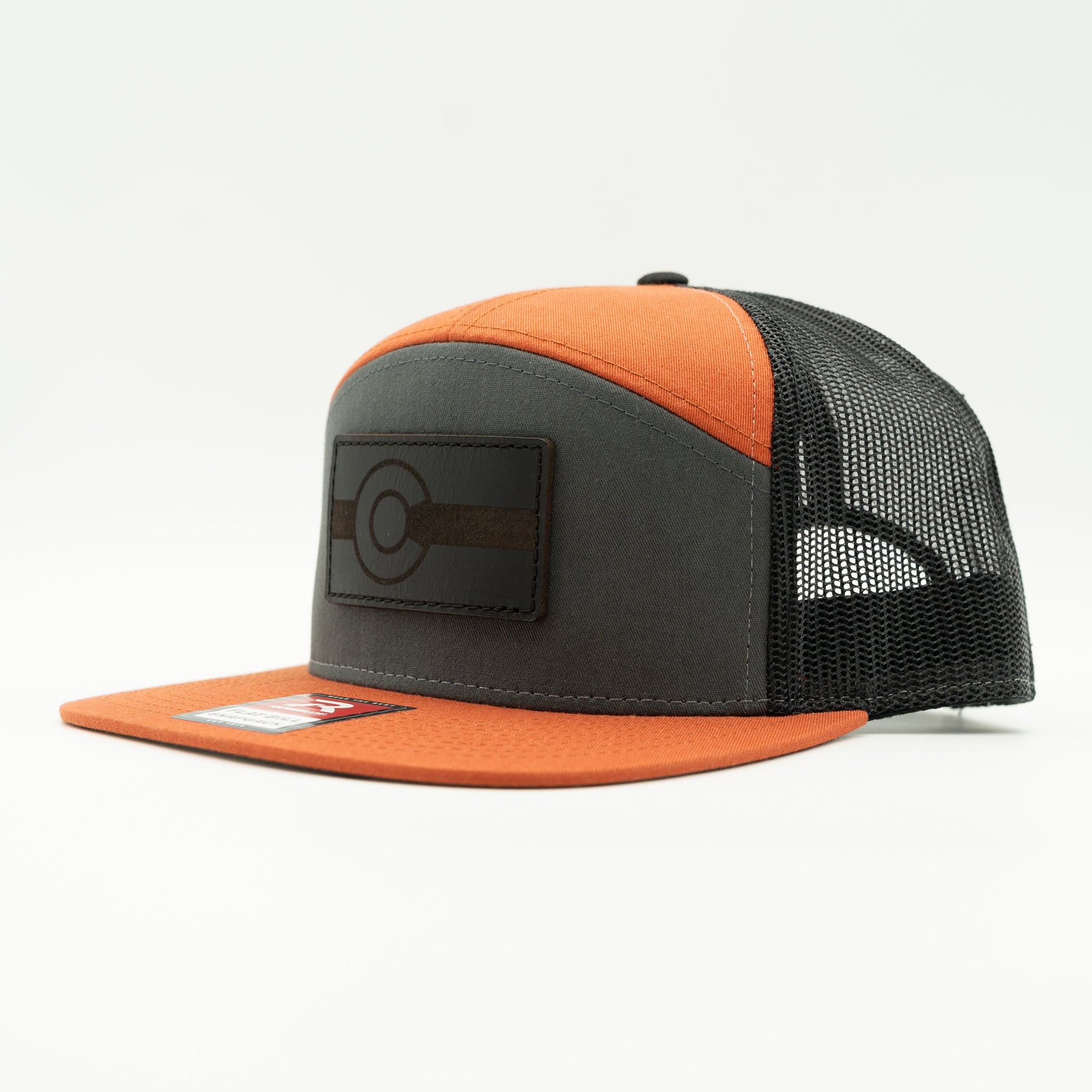 Side view of charcoal and orange Richardson 168 seven panel hat with black leather Colorado flag patch, high profile Colorado trucker hat