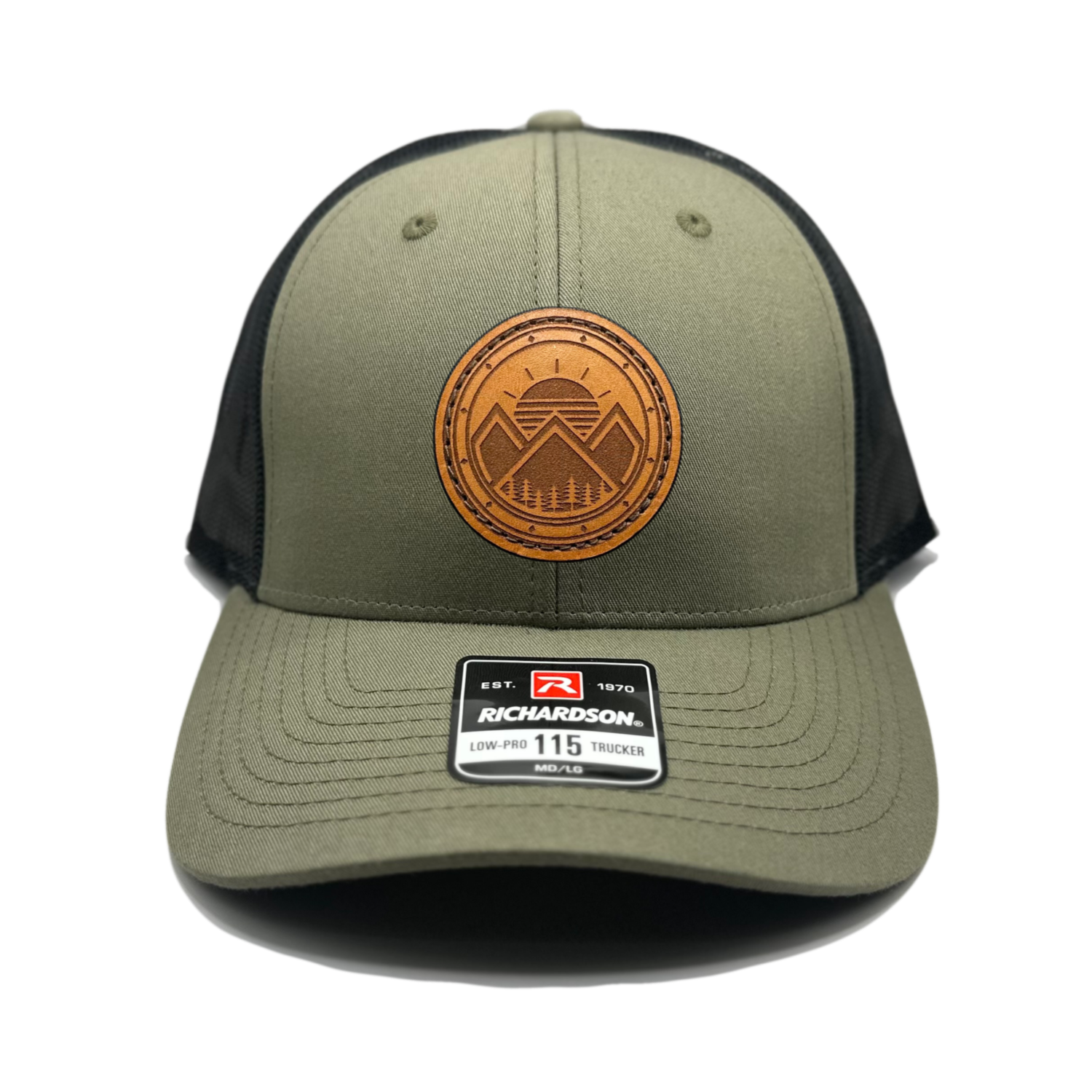 A trendy leather patch hat named Modern Mountains, boasting a unique design with three mountain peaks, a sunrise, pine trees, and a decorative border on a circular patch. Crafted and designed in the USA, this authentic leather patch is skillfully sewn onto a SnapBack adjustable hat. Offered in small and m/l sizes in the Richardson 115 style, as well as multiple colors in the Richardson 112. Inspired by the picturesque surroundings of our Colorado mountain location, this hat is perfect for fashion-forward in