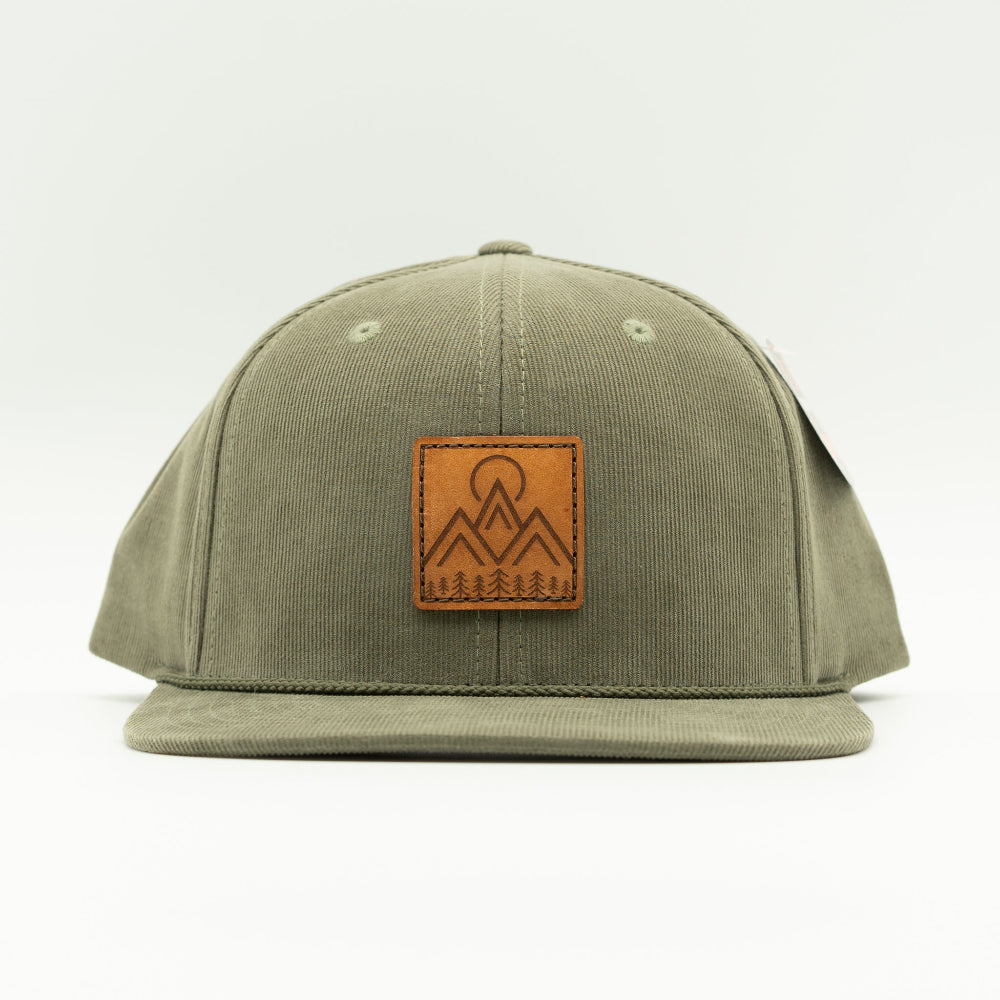 Front view of Moonlite Mountain leather patch rope hat on olive Richardson 253 corduroy, showing square mountain patch, vintage rope, high crown, and flat bill.