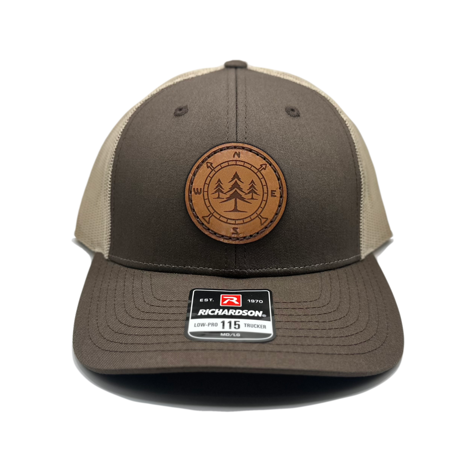 A high-quality leather patch hat named Lost Pines, showcasing a distinctive compass and pine trees design on a circular leather patch. Made in the USA, this hat features genuine leather craftsmanship and is affixed to a brown/khaki Richardson 115 low profile SnapBack hat. Available in small and m/l sizes and various colors, this unique hat is inspired by the picturesque mountains of Colorado. Perfect for hat enthusiasts and those seeking stylish leather patch designs.