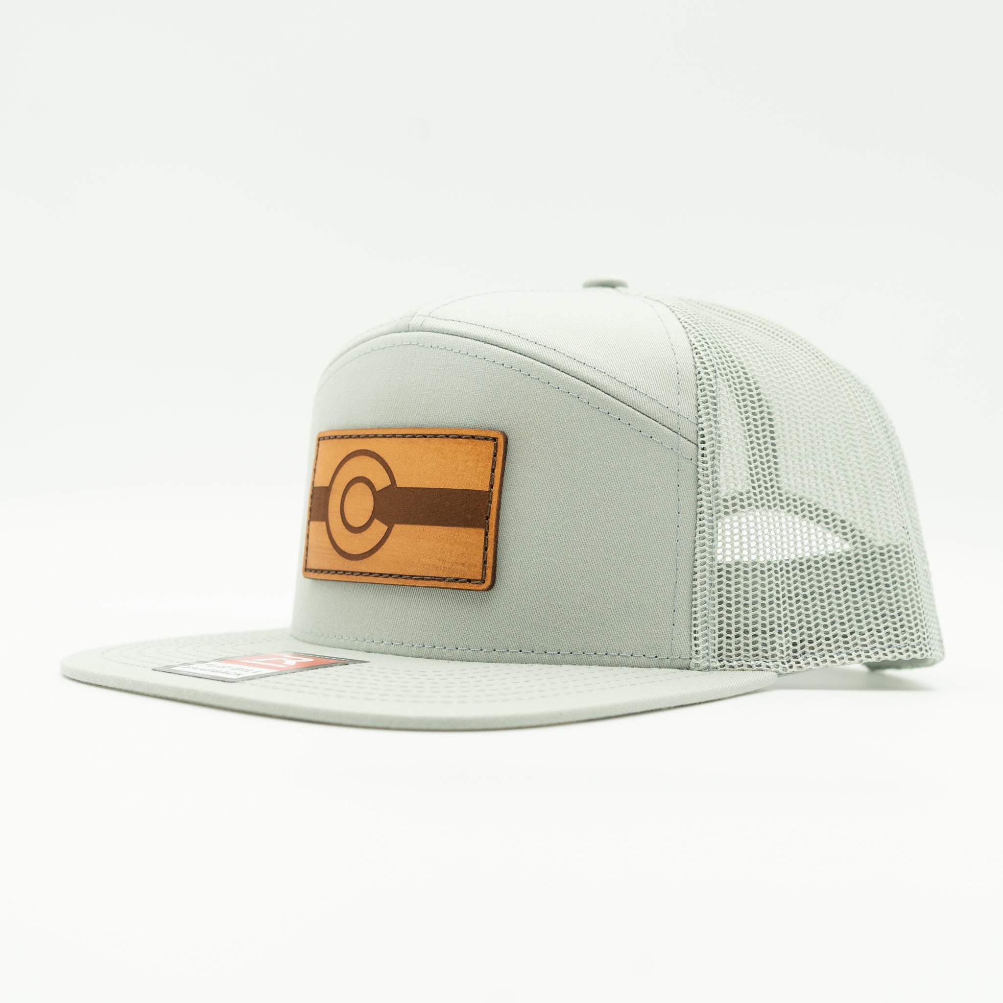 Side view of quarry gray Richardson 168 flat bill trucker hat with light brown leather Colorado flag patch, minimalist Colorful Colorado leather patch hat