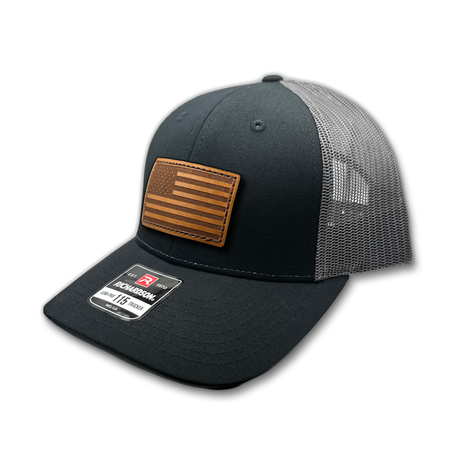 Image of a Black/Charcoal Richardson 115 hat with an American flag patch made of genuine leather, laser engraved and securely sewn onto the hat. The low profile trucker style hat is adjustable to fit small or M/L sizes, offering a versatile and fashionable accessory for any occasion.