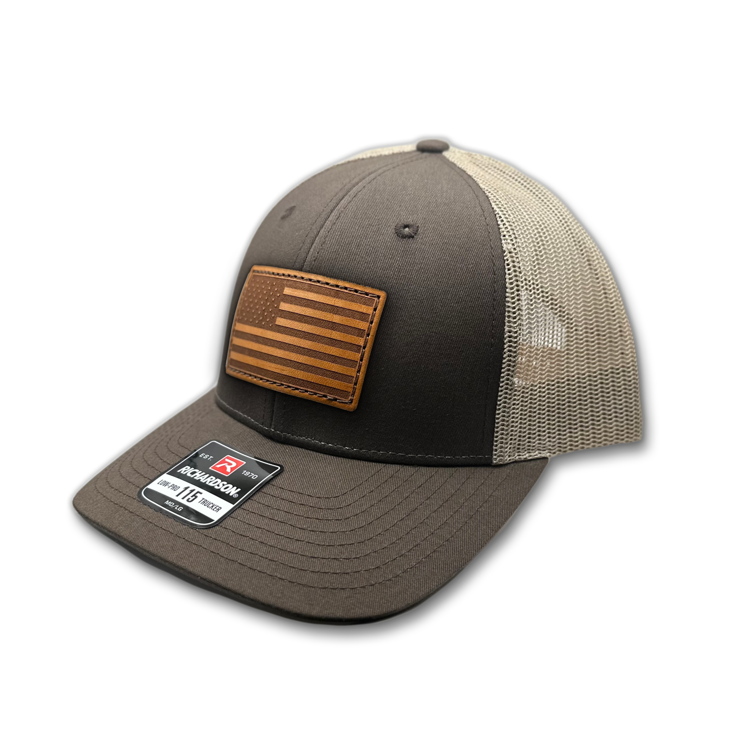 Image of a Brown/Khaki Richardson 115 hat with an American flag patch made of genuine leather, laser engraved and securely sewn onto the hat. The low profile trucker style hat is adjustable to fit small or M/L sizes, offering a versatile and fashionable accessory for any occasion.