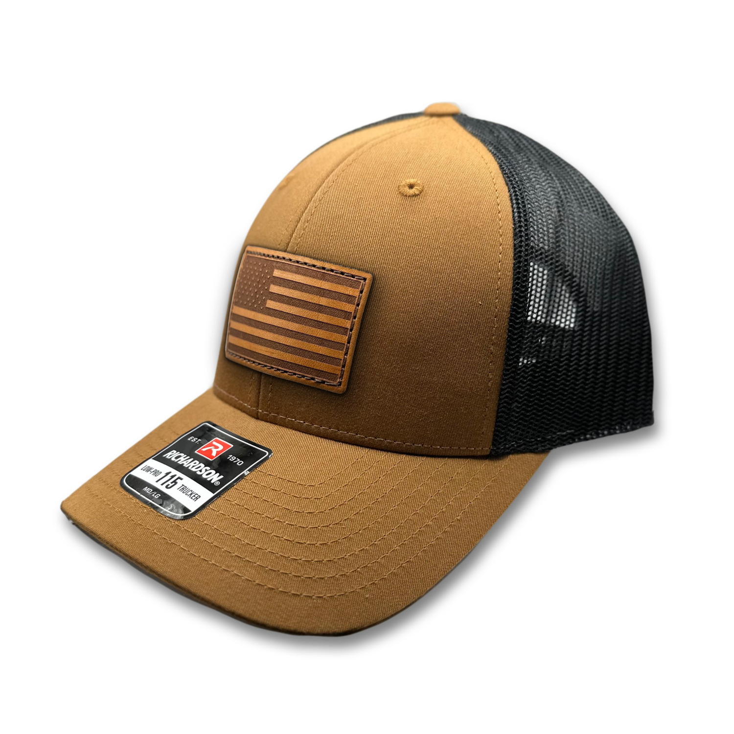 Image of a Carmel/Black Richardson 115 hat with a distinctive American flag patch crafted from genuine leather, laser engraved and securely sewn onto the hat. The hat features a fully adjustable snap back and is a low profile trucker style hat that can be adjusted to fit small or M/L sizes, offering a versatile and fashionable accessory for any occasion.