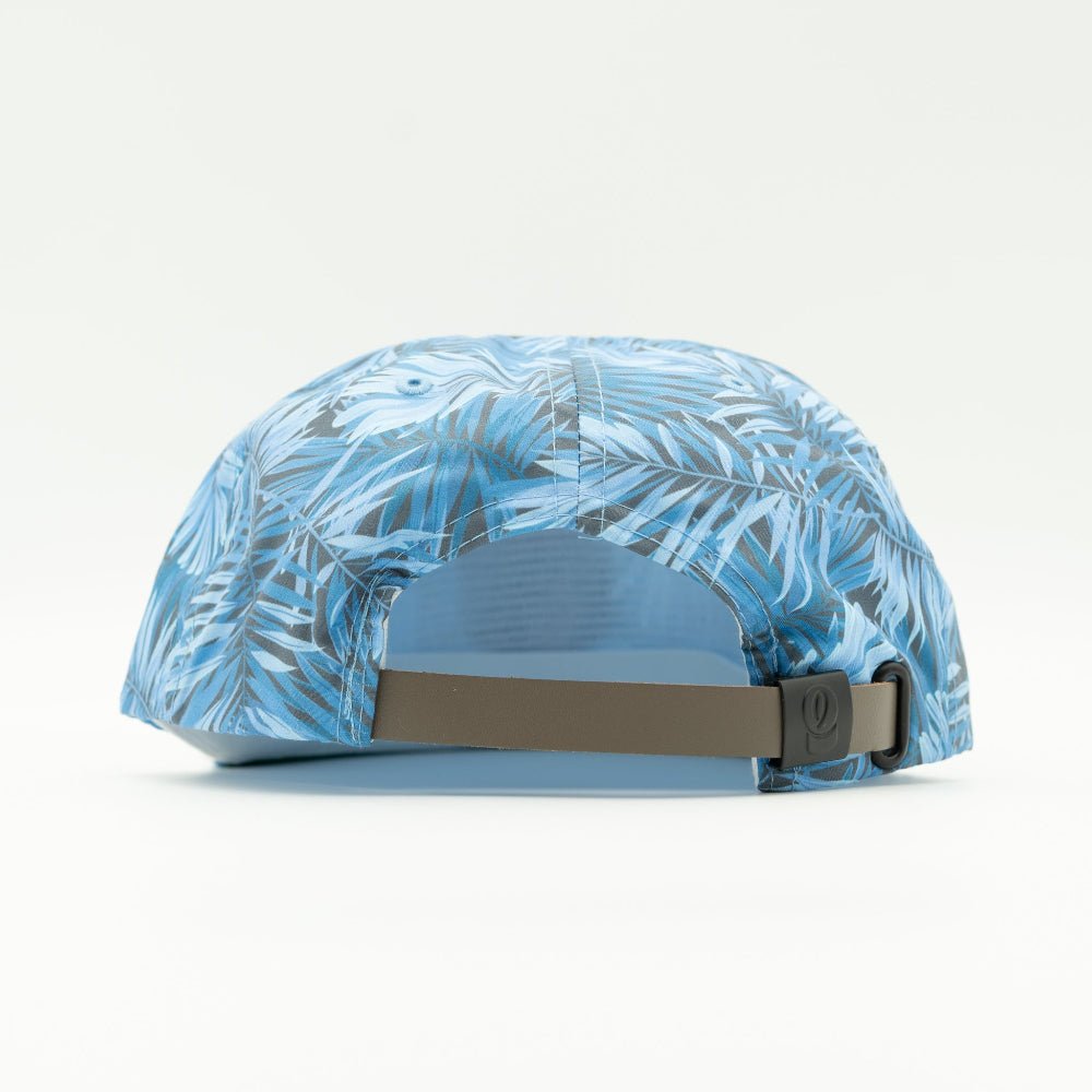A blue and white tropical palm leaf patterned baseball cap shown from the back, featuring a brown adjustable strap with a black metal buckle.
Color: Blue Hawaiian