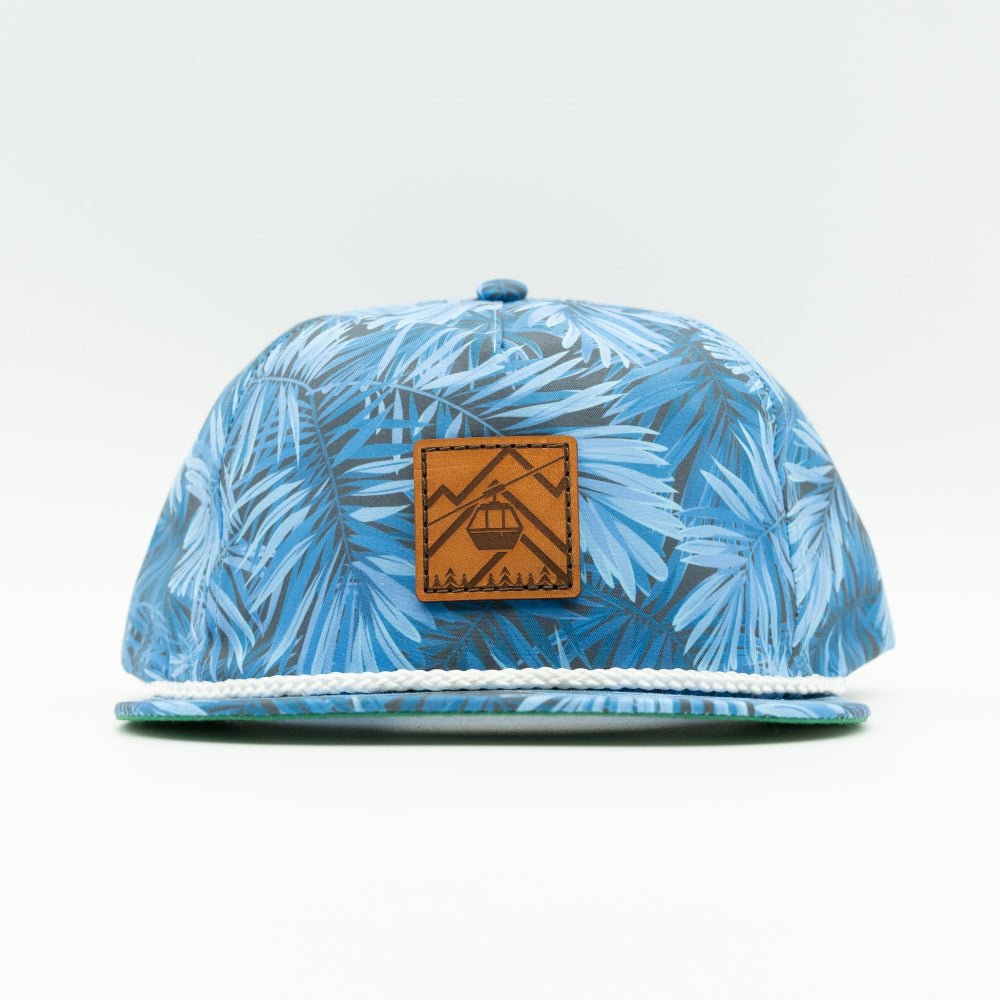 Front view of the Gondola Hat in Blue Pine by Outer Wings, displaying a genuine leather patch with detailed winter-themed designs including skiers, ski lifts, and pine trees. Crafted on an Imperial Umpqua rope hat with a structured mid-profile, moisture-wicking sweatband, and adjustable leather strap.
Color: Blue Hawaiian
