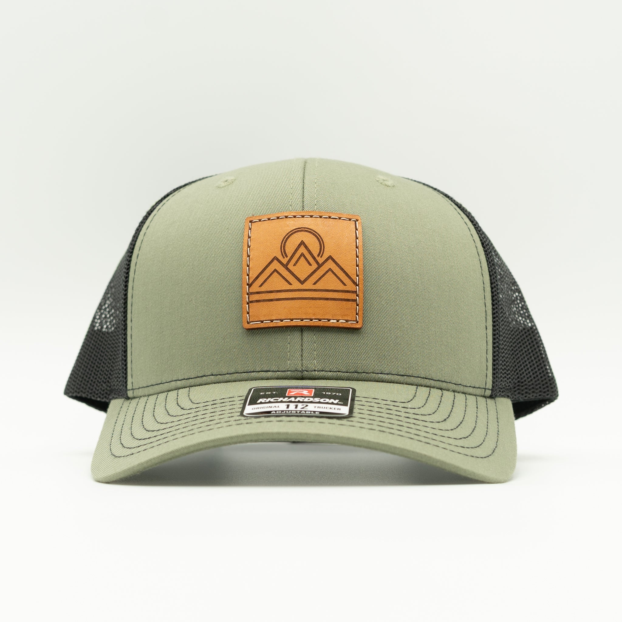 Front view of Lunar Ridge loden and black Richardson 112 trucker hat with sewn leather mountain patch
Color: Loden/Black