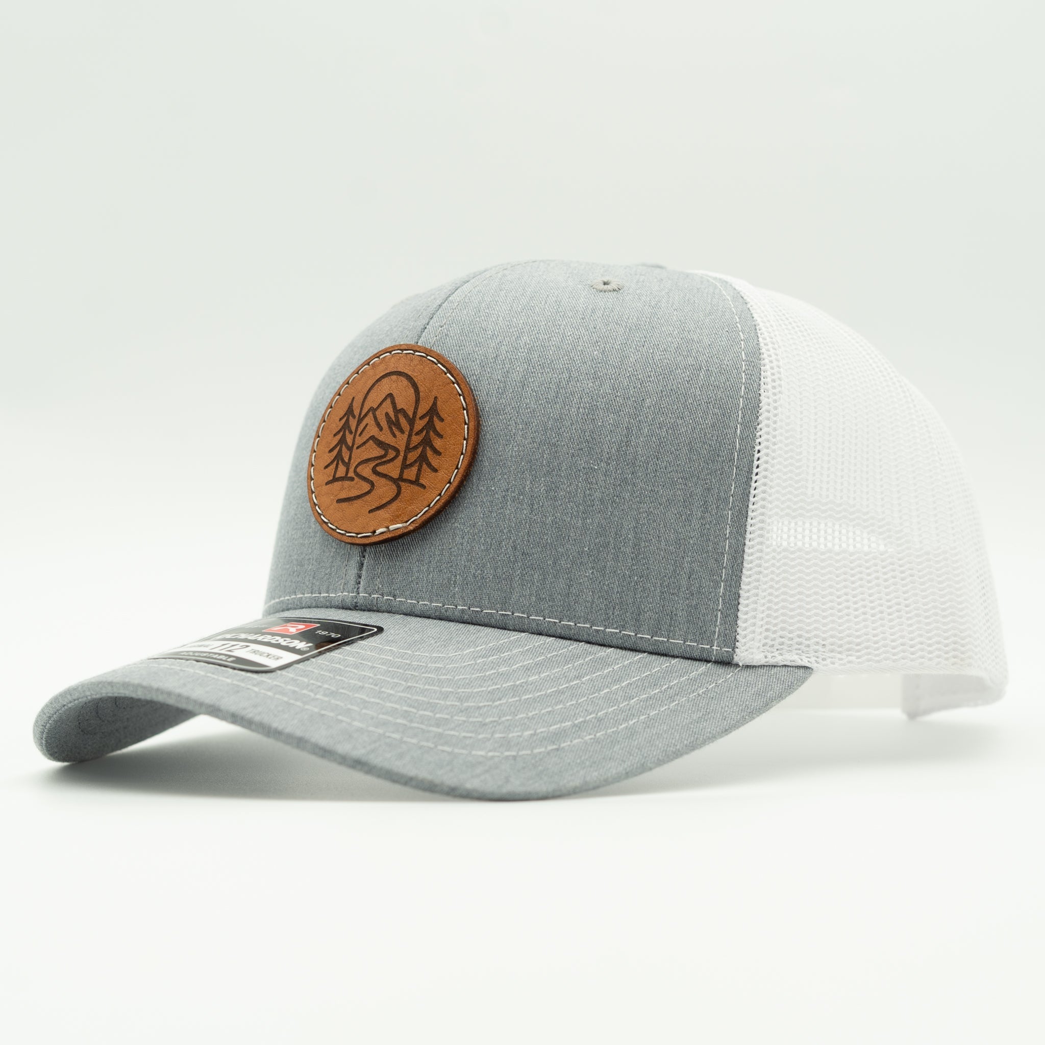 Side view of The Passage heather grey and white Richardson 112 leather patch mountain trucker hat.