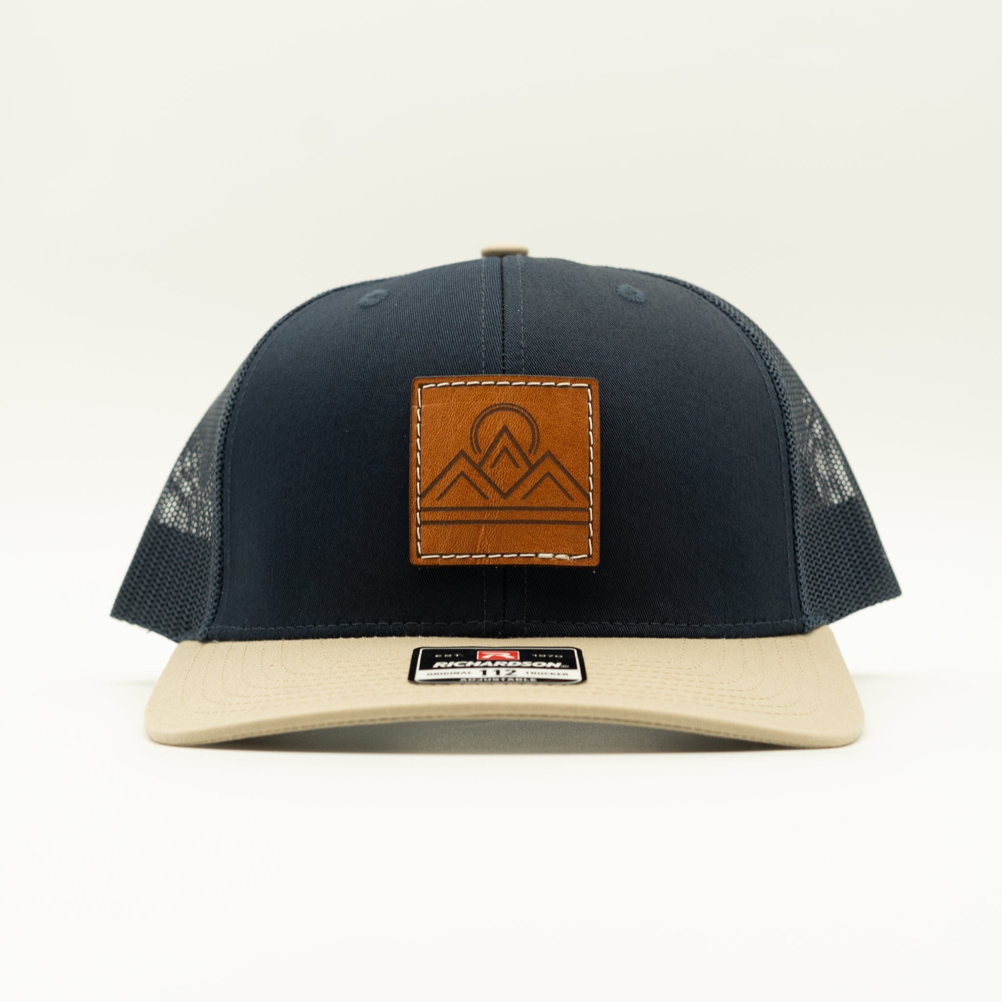 Front view of Lunar Ridge navy and khaki combo Richardson 112 trucker hat with sewn veg tan mountain patch
Color: Navy/Khaki Combo