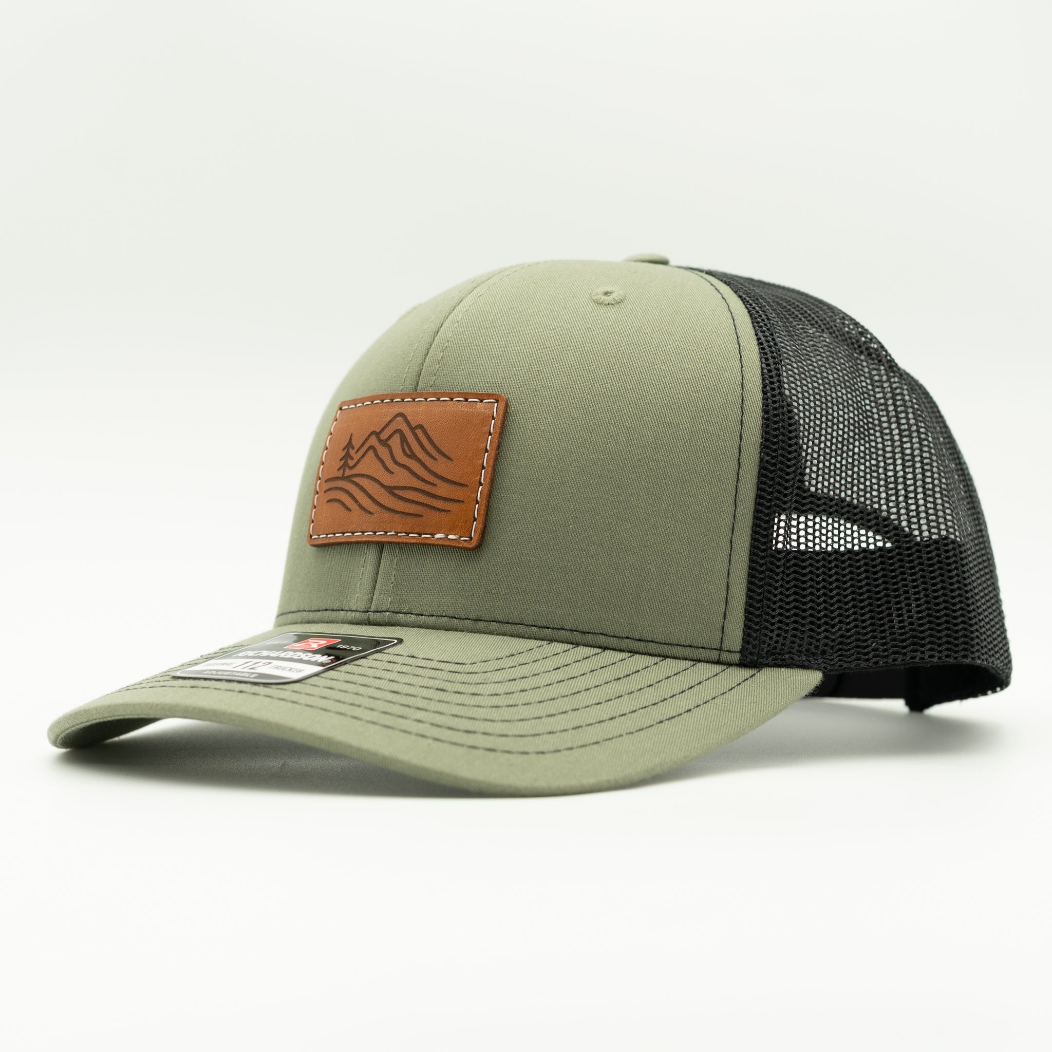 Side view of loden and black Richardson 112 Driftline leather patch hat, green mountain trucker with mesh back.
Color: Loden/Black