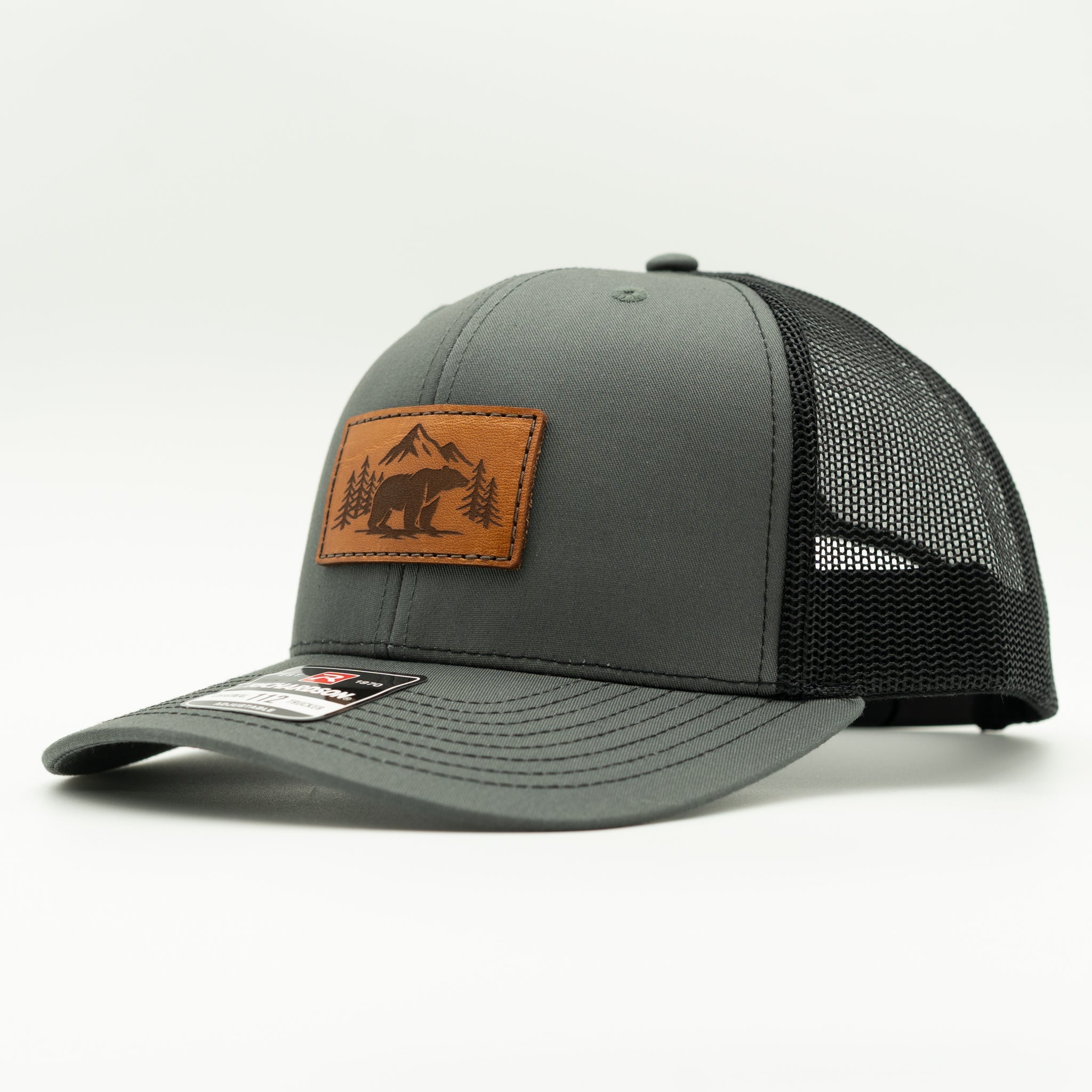Side view of Bearline Peak leather patch hat on charcoal and black Richardson 112, highlighting mid profile crown, leather patch, and mesh back.
Color: Charcoal/Black
