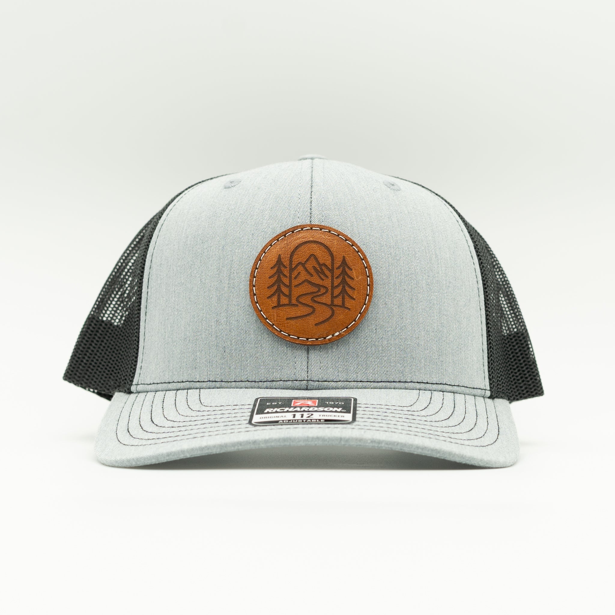 Front view of heather grey and black Richardson 112 The Passage mountain hat with round leather patch.