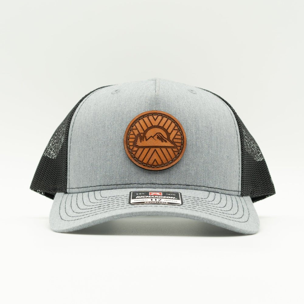 Front view of heather grey/black Richardson 112FP with sewn Mosaic Sunset full-grain leather patch and seamless front panel.
Color: Heather Grey/Black