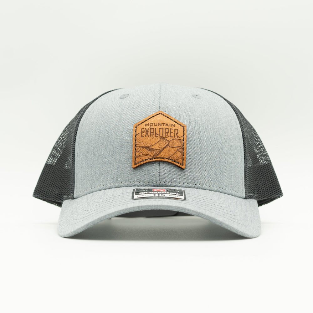 Front view of heather grey and dark charcoal Mountain Explorer leather patch low profile hat, Richardson 115 mountain trucker with sewn real leather patch for everyday wear.