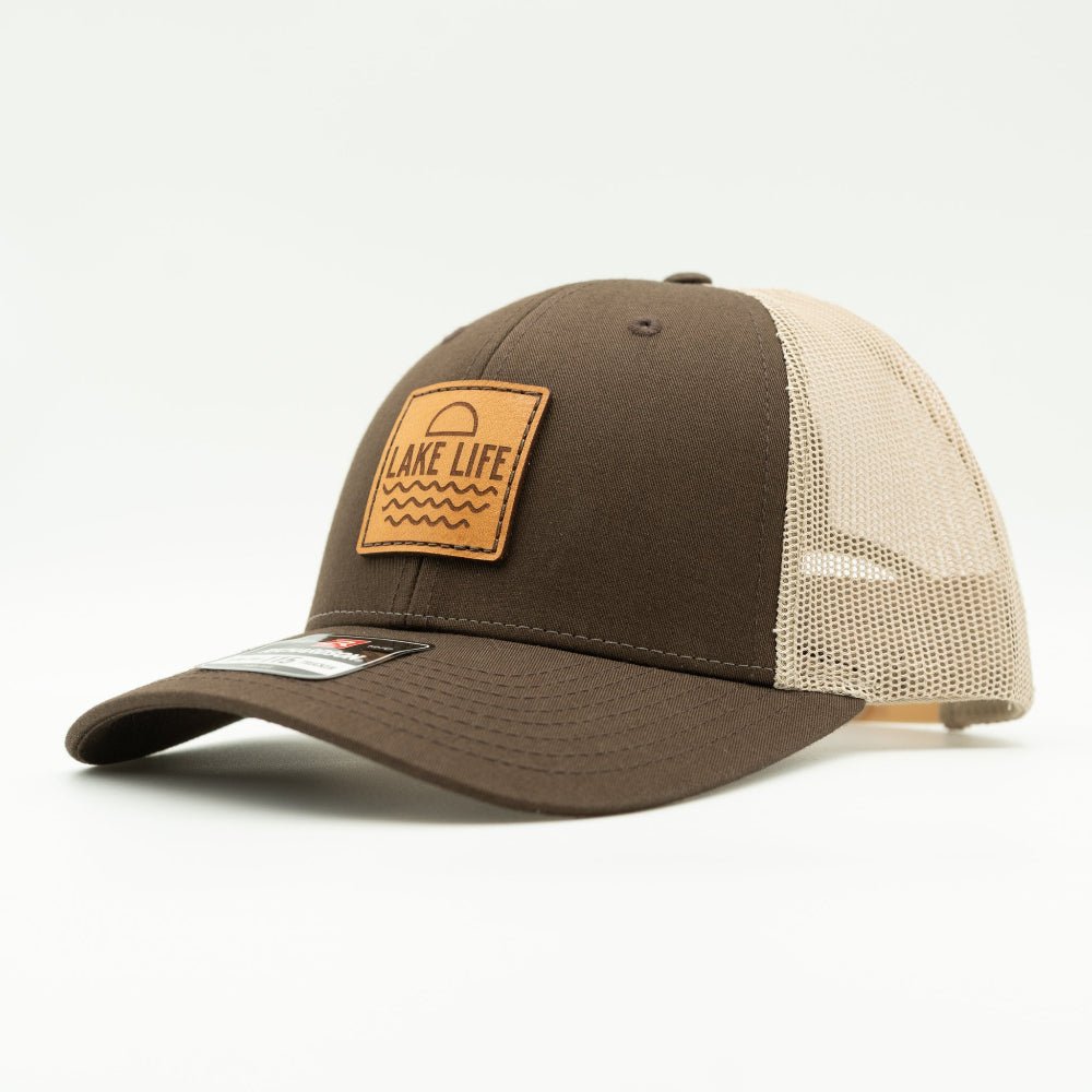 Side view of Lake Life leather patch hat on brown and khaki Richardson 115, showing shallow crown, curved bill, mesh back, and sewn leather patch for lake weekends.
Color: Brown/Khaki