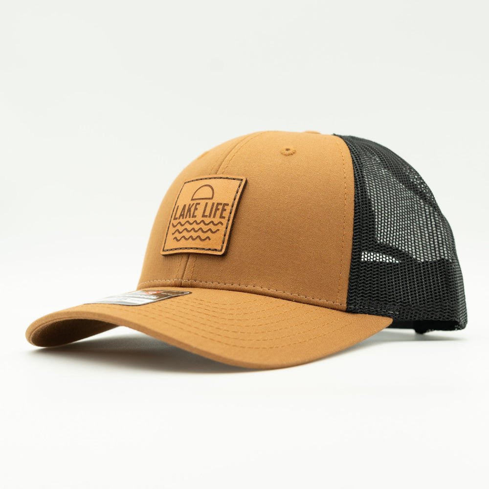 Side view of Lake Life leather patch hat on caramel and black Richardson 115, showing low profile fit, engraved leather patch, curved bill, and black mesh back.
Color: Caramel/Black