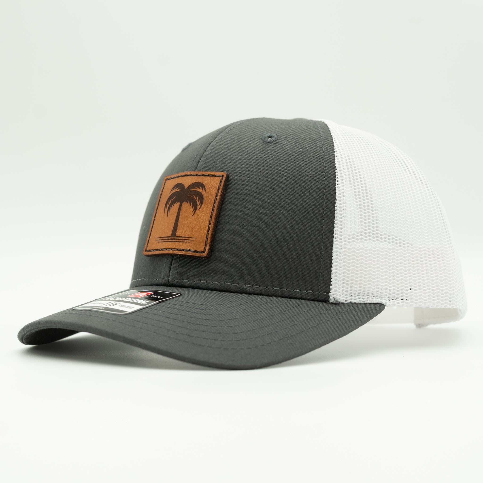 Charcoal and white Solo Palm Richardson 115 low profile trucker hat, side profile with charcoal front panel, white mesh, and palm patch.