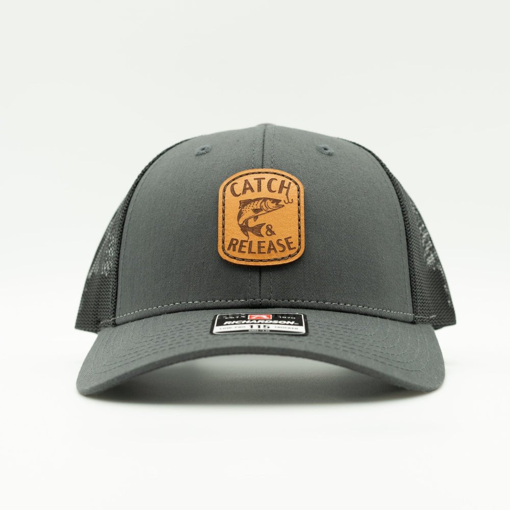 Front view of charcoal Richardson 115 low profile trucker hat with Catch & Release leather patch and curved bill.
Color: Charcoal/Black