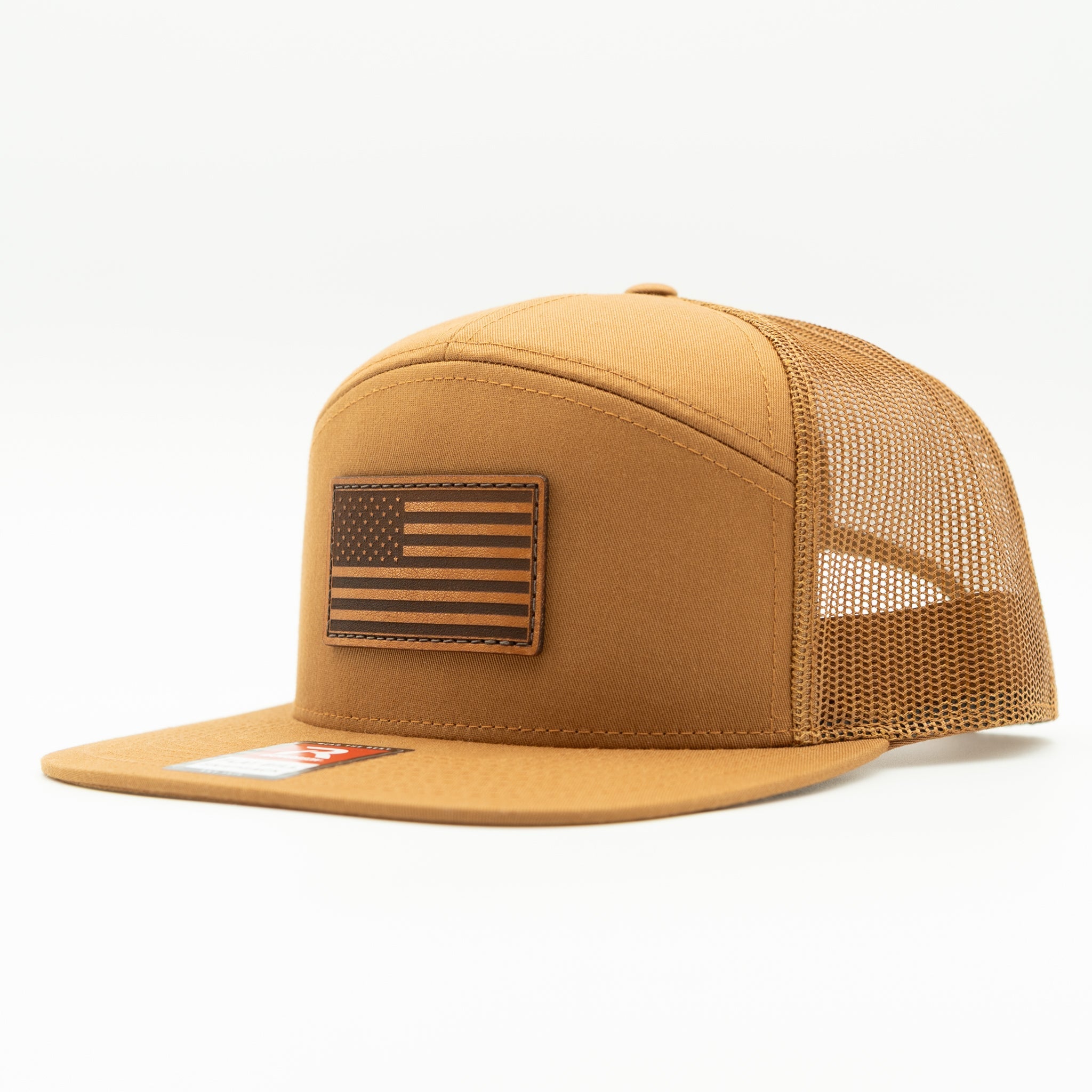 Caramel Richardson 168 seven panel flat bill trucker hat with light brown American Flag leather patch, side view showing high profile crown and mesh back.
Color: Caramel 168 (OSFM)