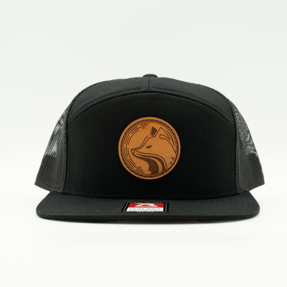 Front view of Fox Hollow leather patch hat on solid black Richardson 168 seven panel, flat bill with fox badge and mesh back.
Color: Black/Black 168 (OSFM)