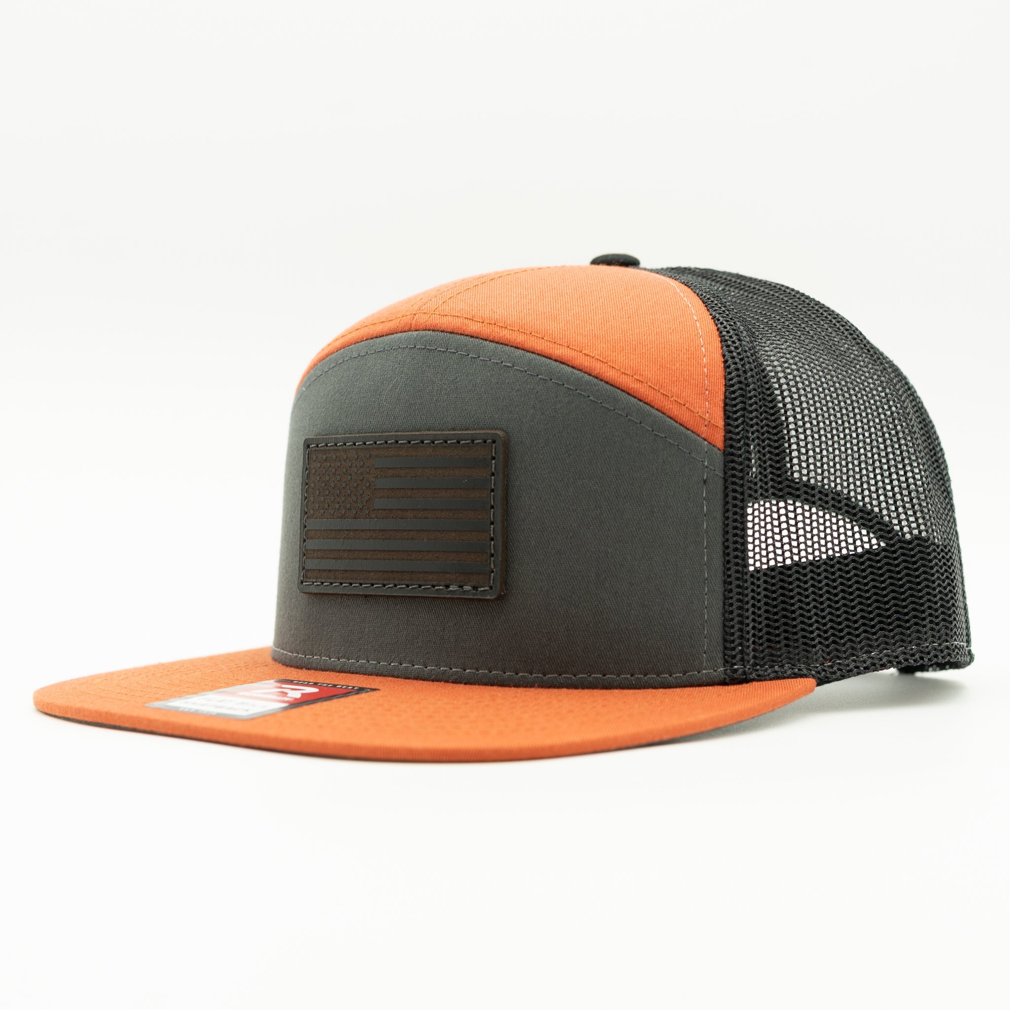 Charcoal, orange, and black Richardson 168 seven panel trucker hat with black American Flag leather patch, side view showing bold orange bill and mesh back.
Color: Charc/Orange/Black 168 (OSFM)