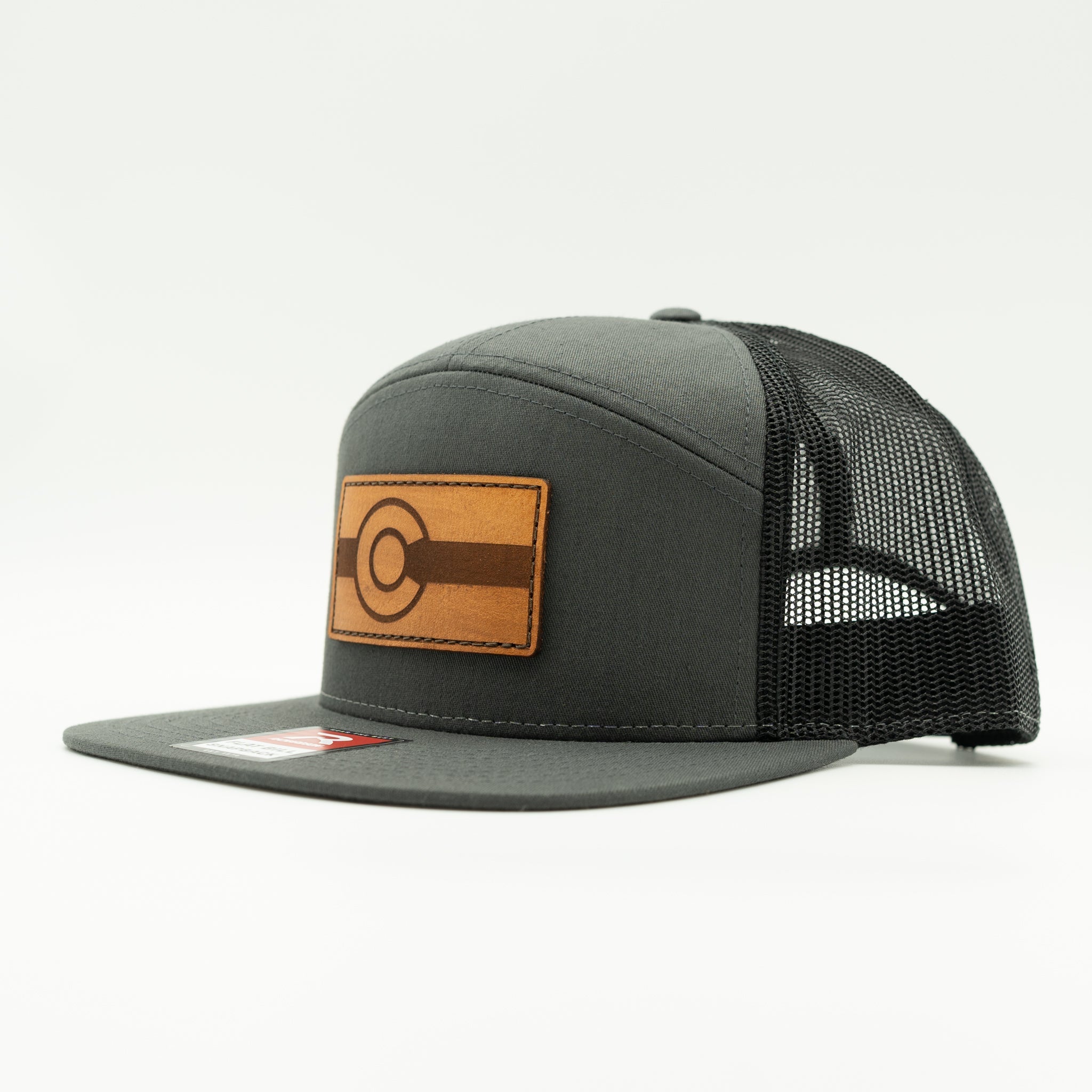 Side view of charcoal and black Richardson 168 flat bill trucker hat with light brown leather Colorado flag patch, Colorful Colorado leather patch hat
Color: Charcoal/Black 168 (OSFM)