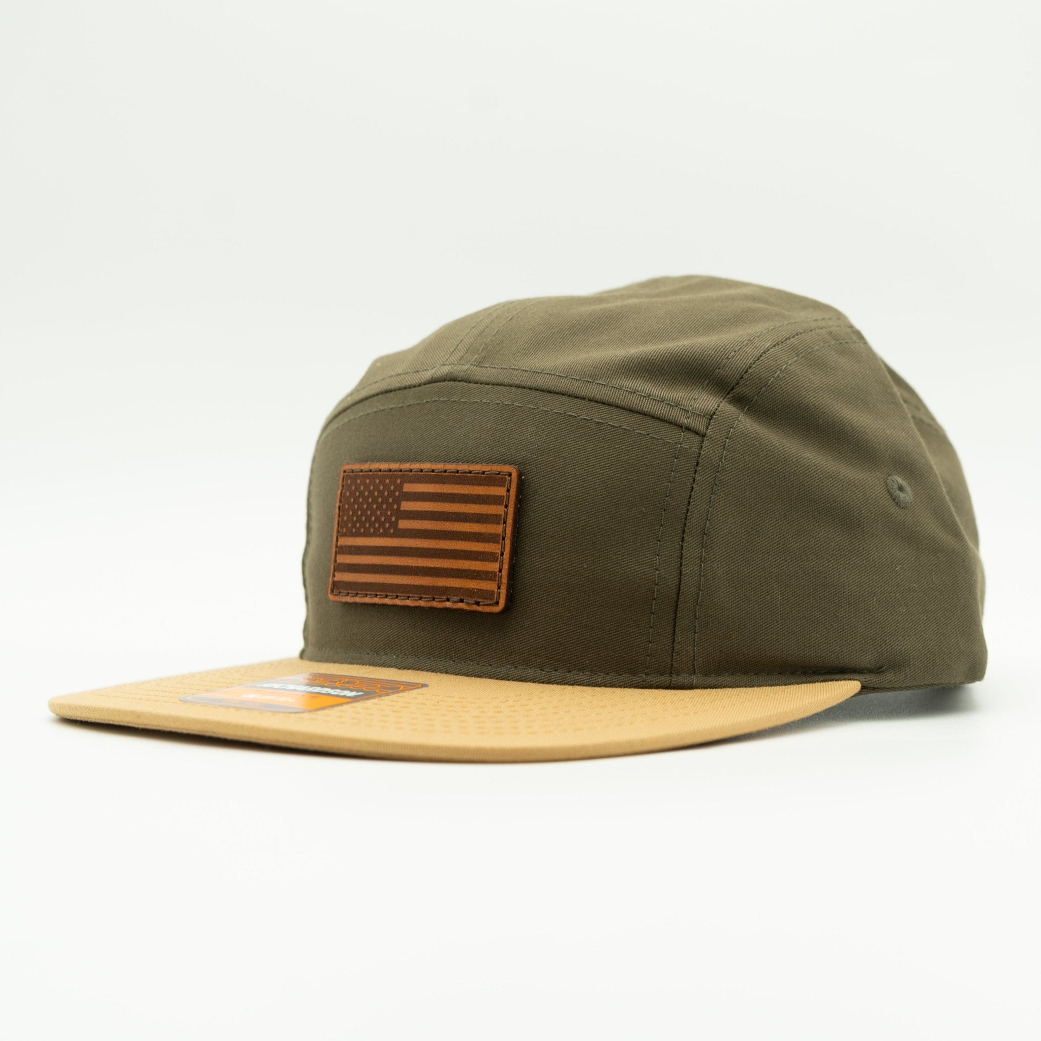 Green cap with brown leather patch featuring an American flag on a white background
Color: Loden/Biscuit