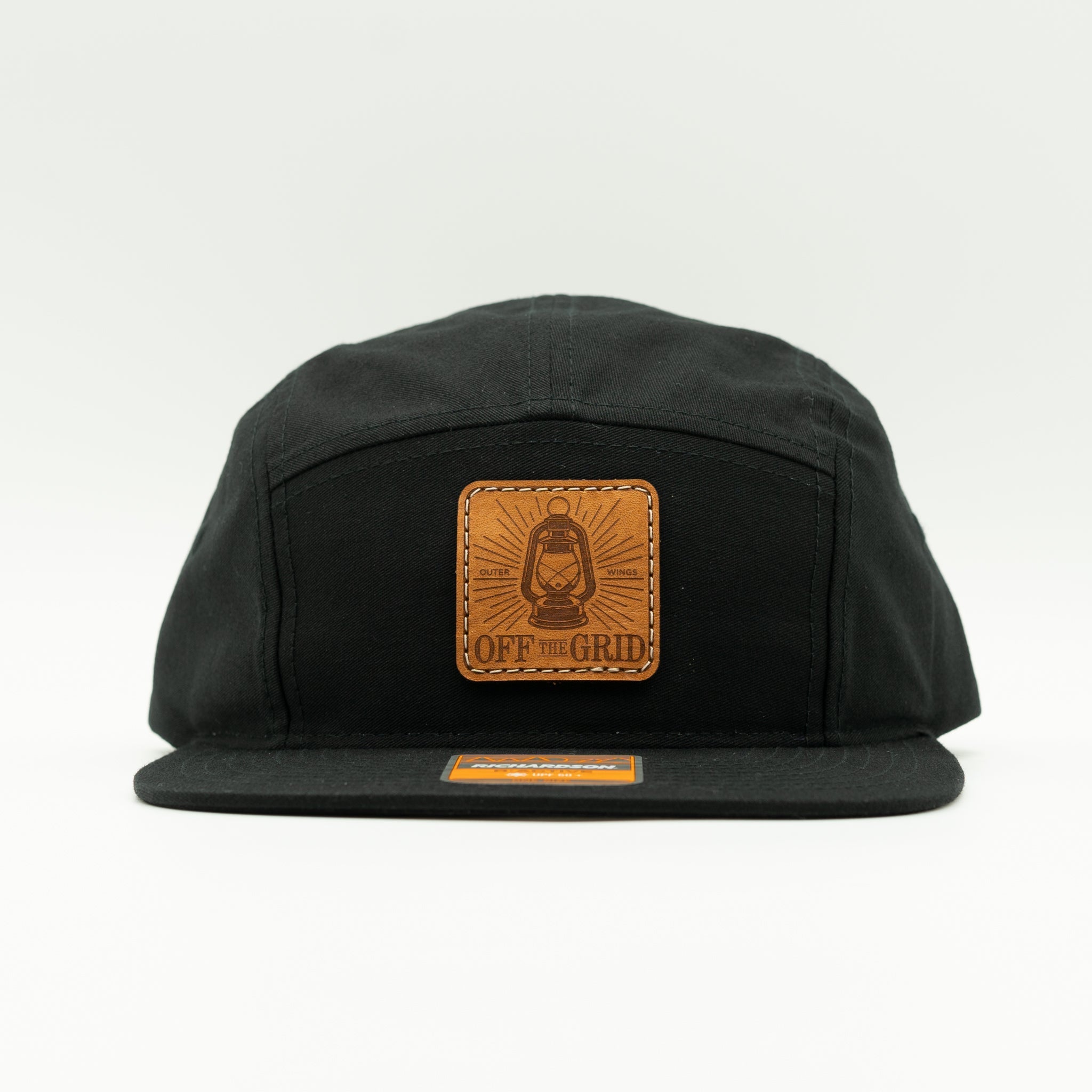 Black Off The Grid leather patch camper hat front view, Richardson 217 five panel with flat bill for hiking, travel, and everyday wear.