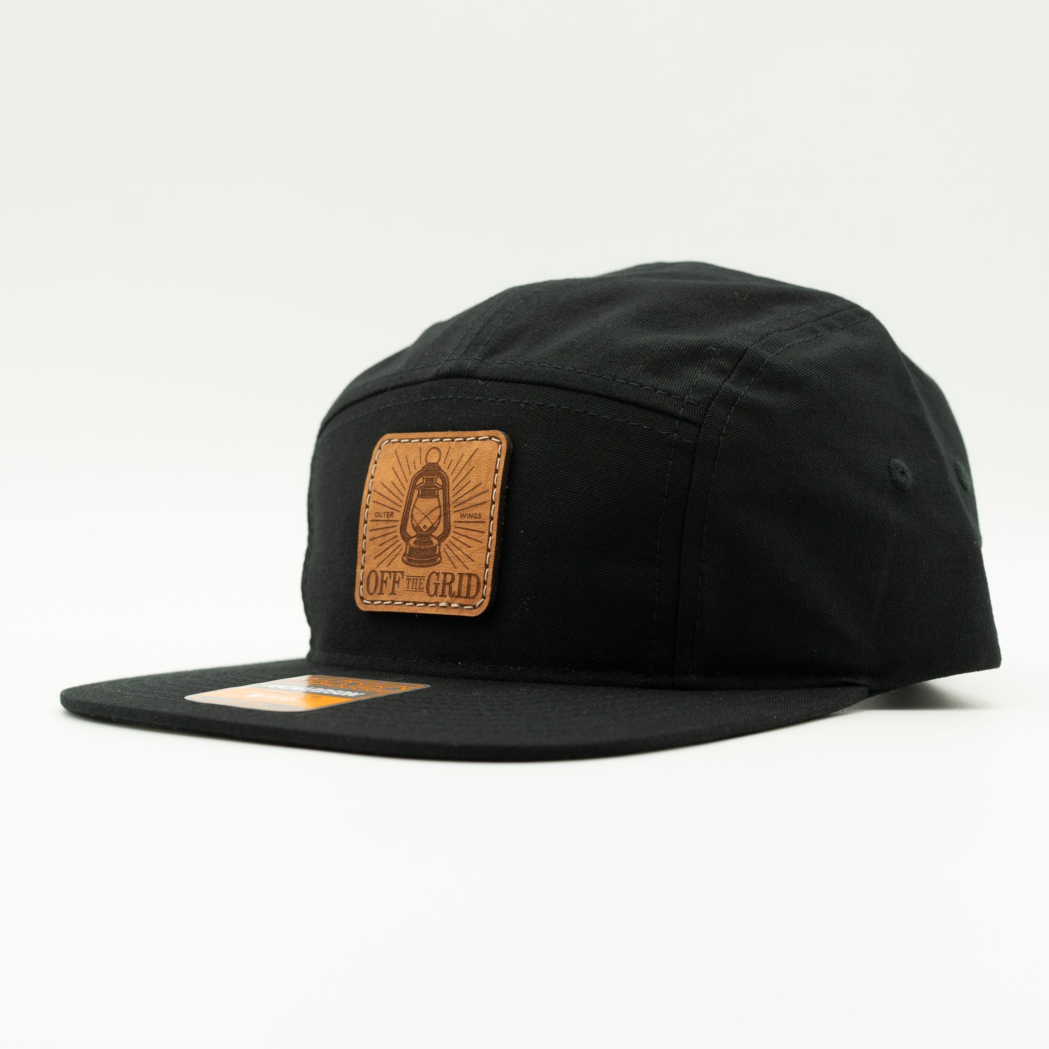 Black Off The Grid Richardson 217 camper hat side view with sewn leather patch and flat bill, lightweight adventure leather patch hat.