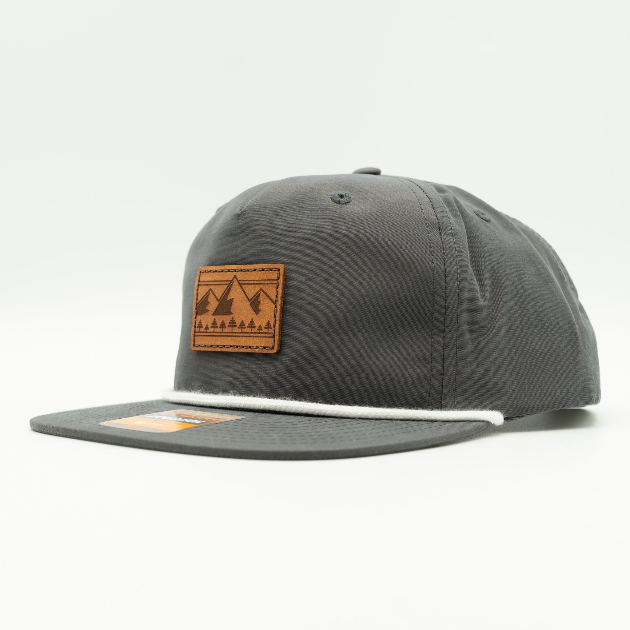 Side view of charcoal Richardson 256 Ridgeline mountain rope hat, showing leather mountain and pine patch, flat rope bill, and low profile crown.