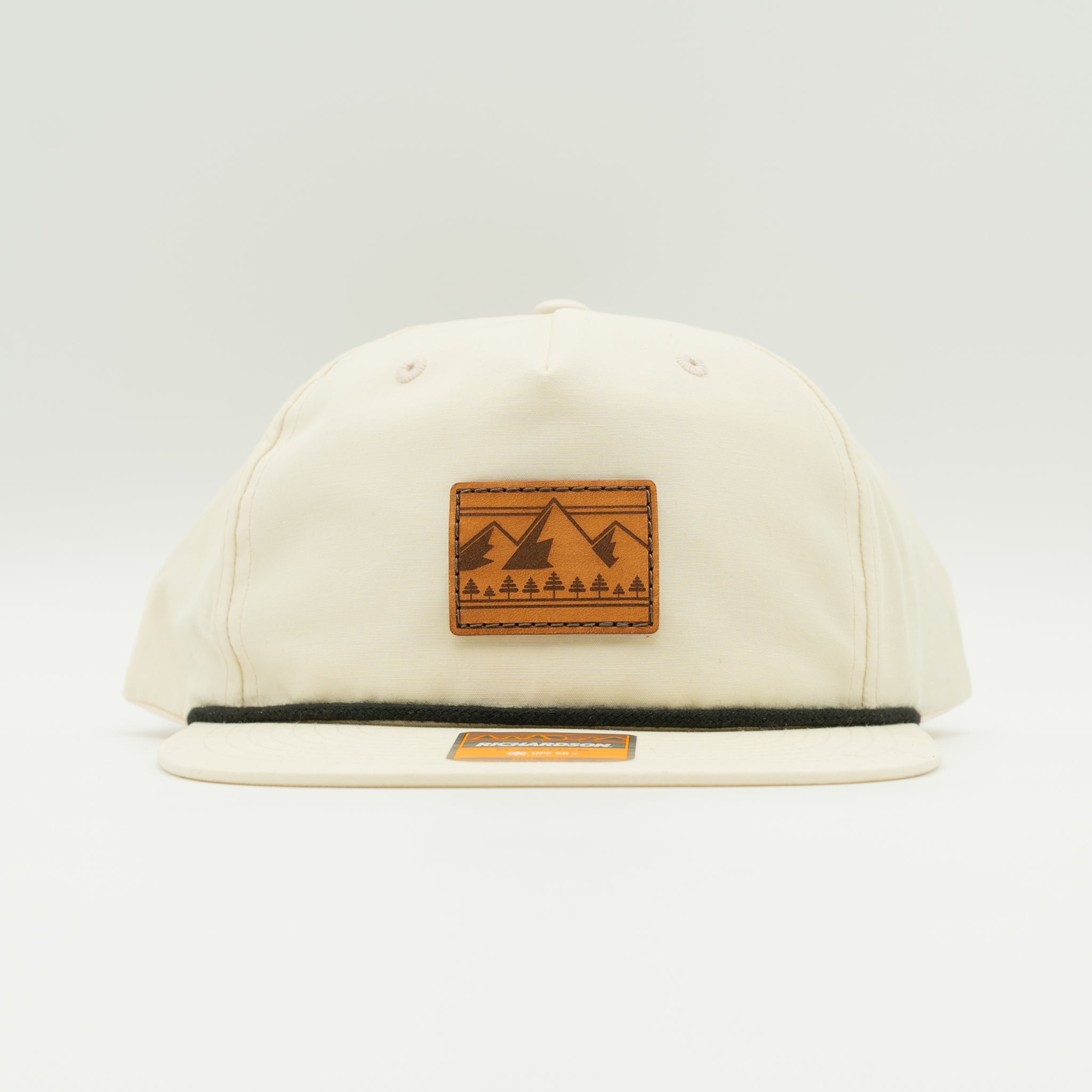 Front view of birch Richardson 256 Ridgeline rope hat with square leather mountain and pine patch, flat bill with rope accent, lightweight UPF 50+ mountain hat.