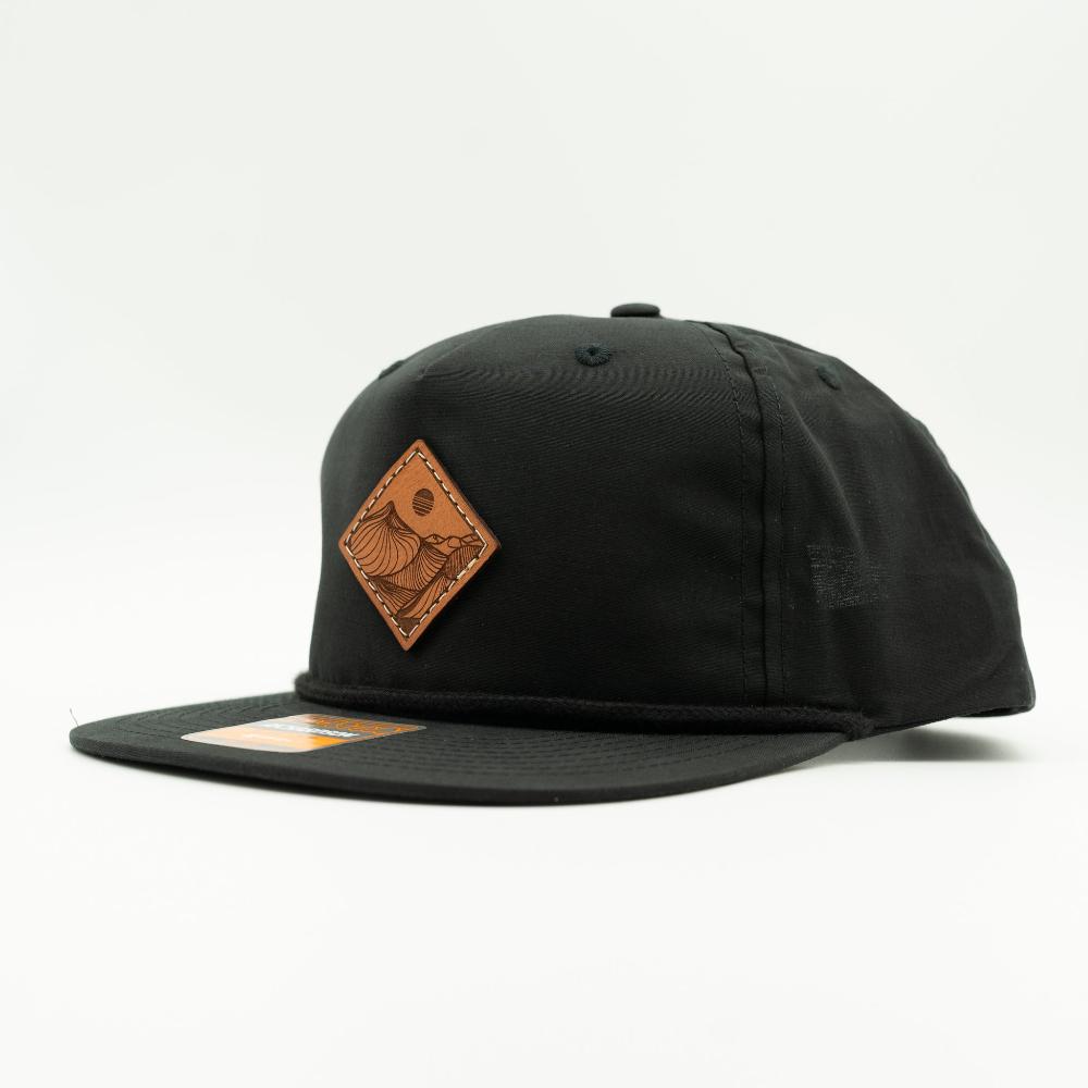 Side view of black Richardson 256 Desert Mountain rope hat with engraved leather patch and rope detail, low profile flat bill snapback.
Color: Black