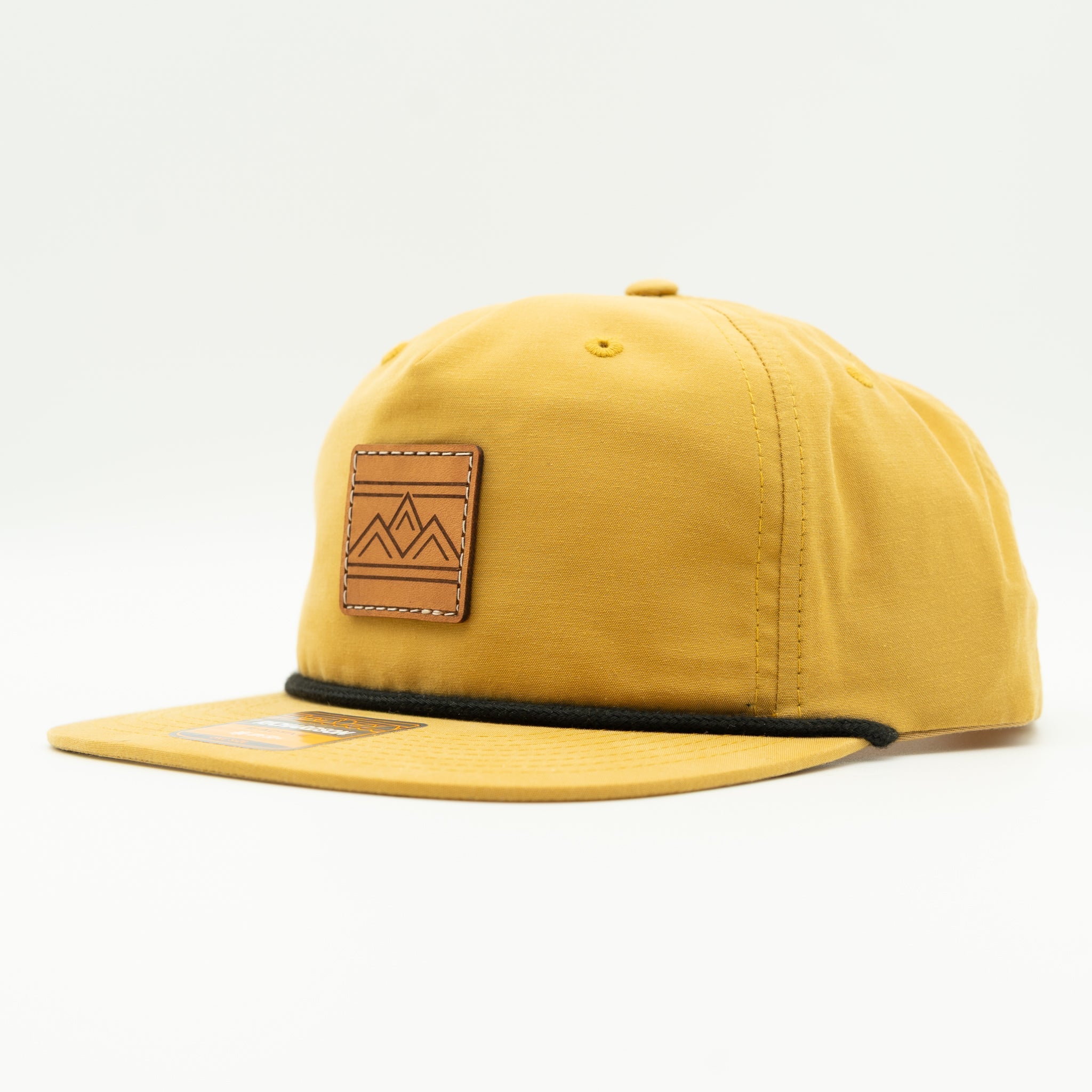 Rustic Ridge biscuit and black Richardson 256 rope hat side view, tan crown with black bill, braided rope, and sewn leather patch.