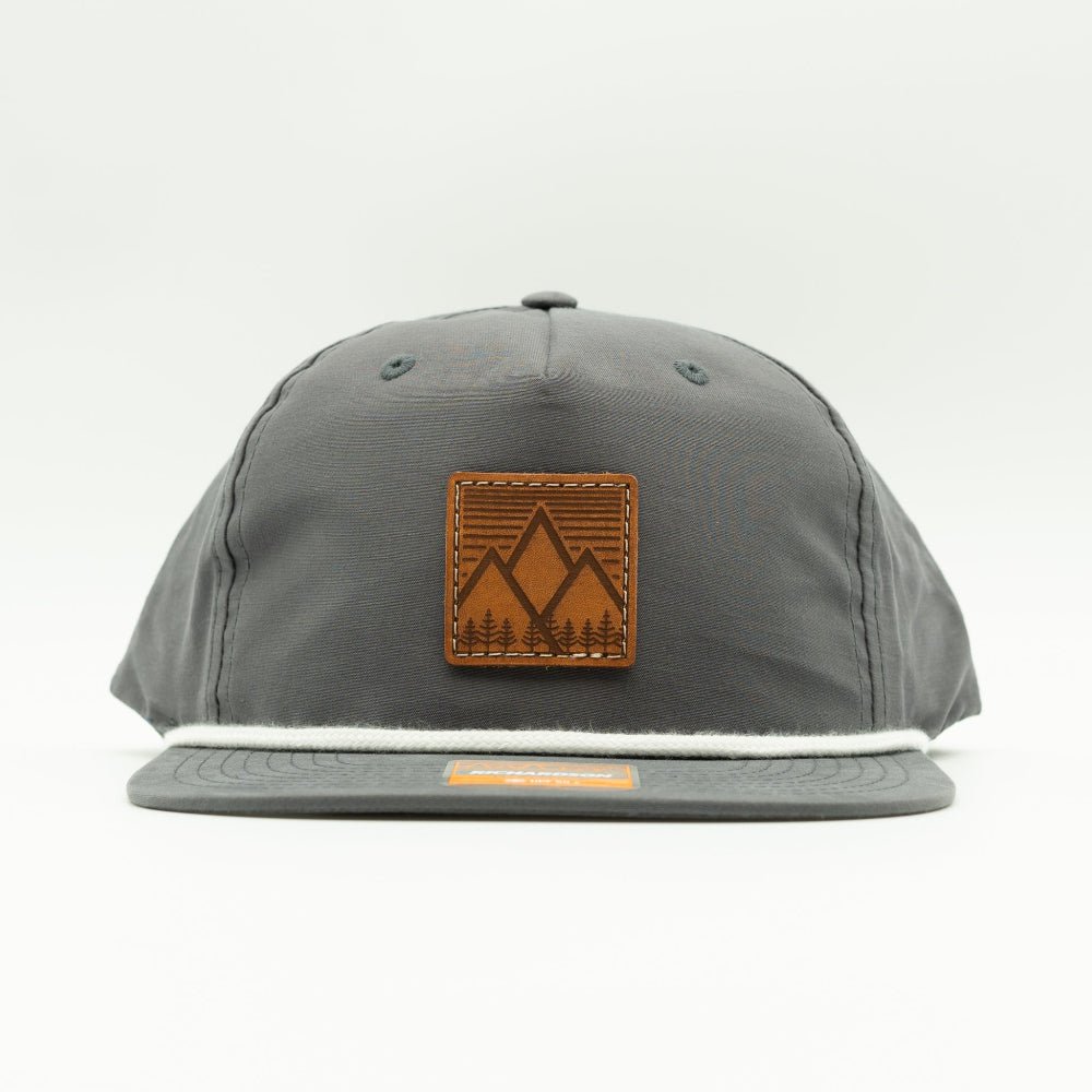 Front view of charcoal Richardson 256 Mountain West rope hat, featuring square leather mountain patch, flat bill with rope detail, and low profile 5-panel design.