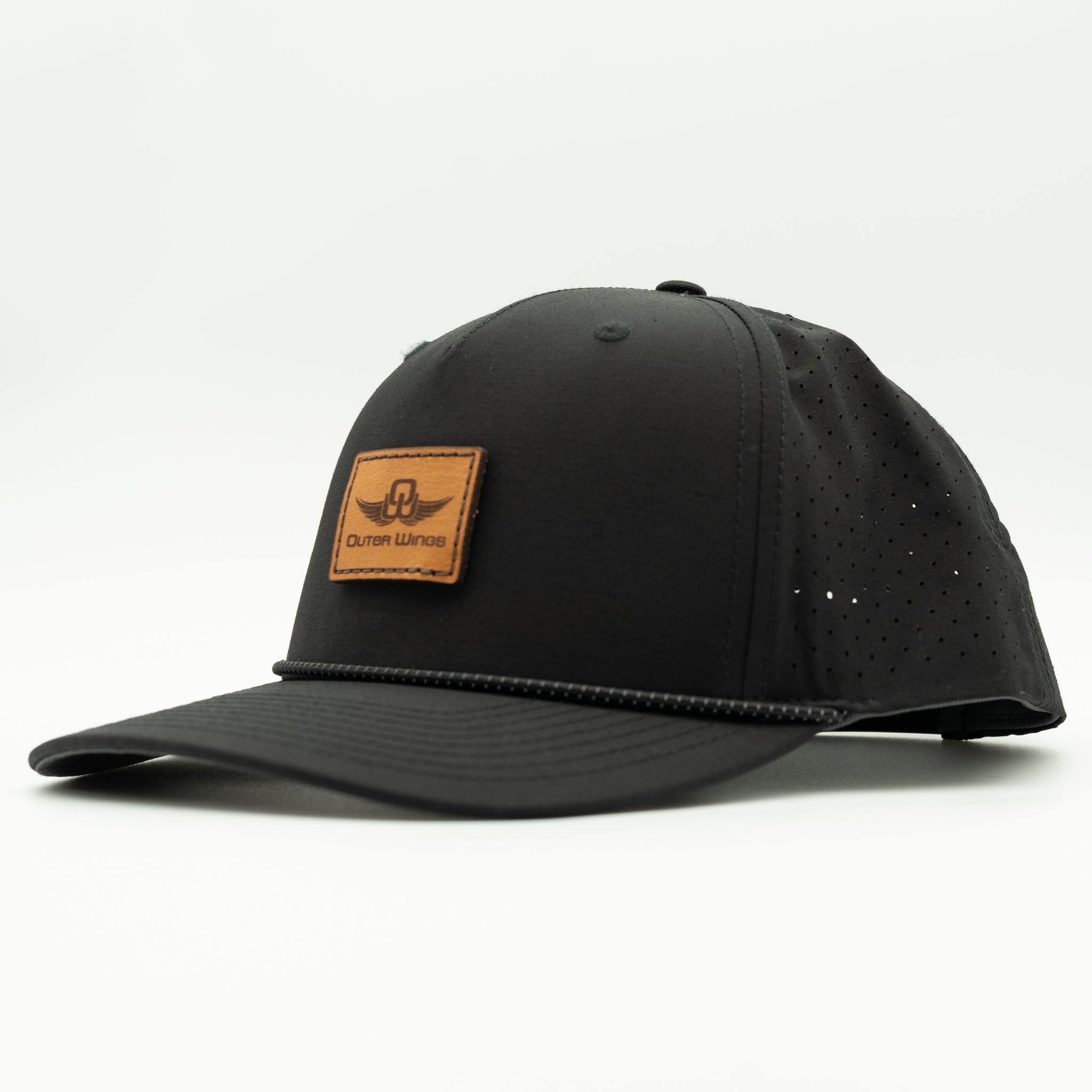 A black baseball cap with perforated side panels and a Black leather patch on the front displaying the 'Outer Wings' logo, shown against a plain white background.
Color: Black
