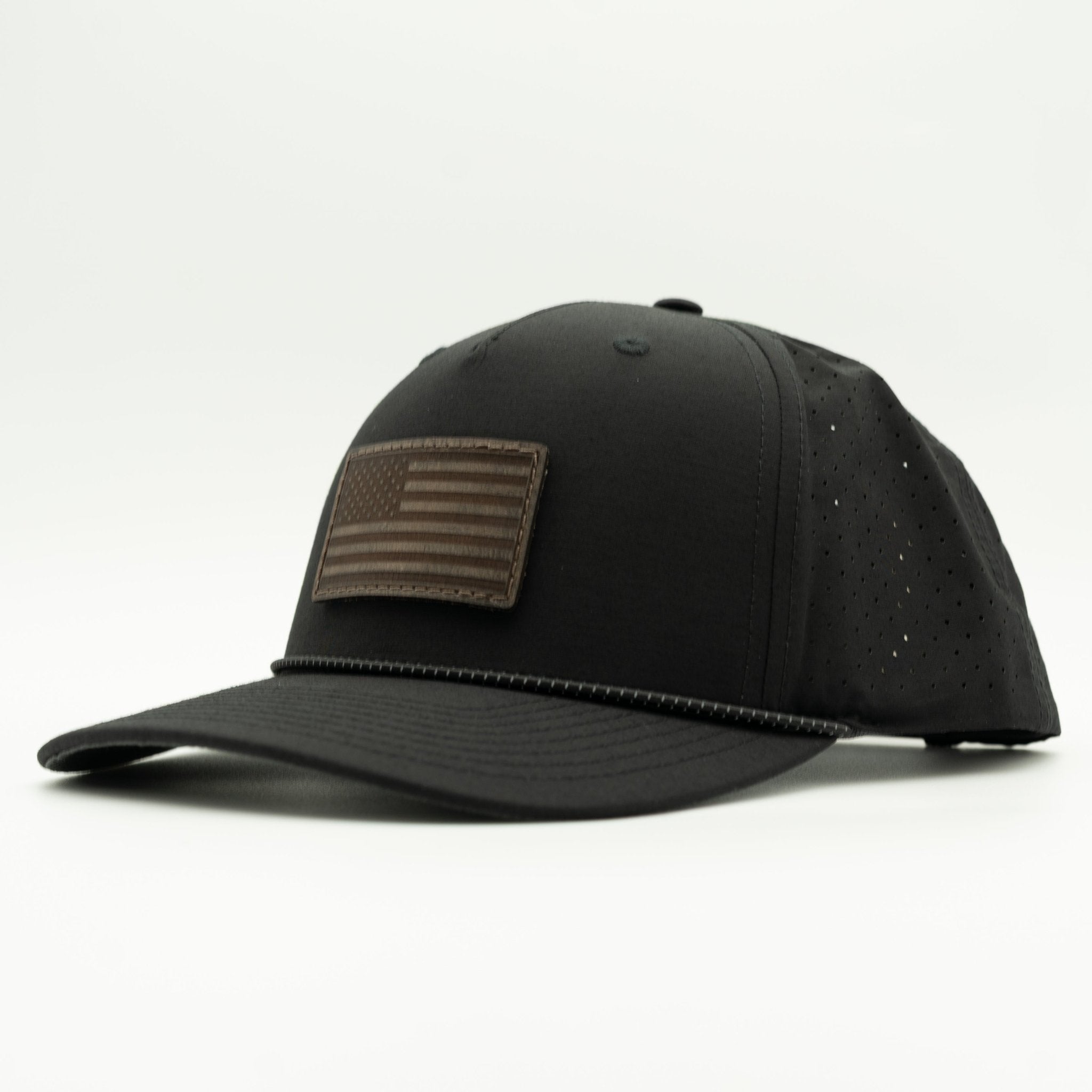 A black baseball cap with a brown leather American flag patch on the front, photographed on a clean white background.
Color: Black