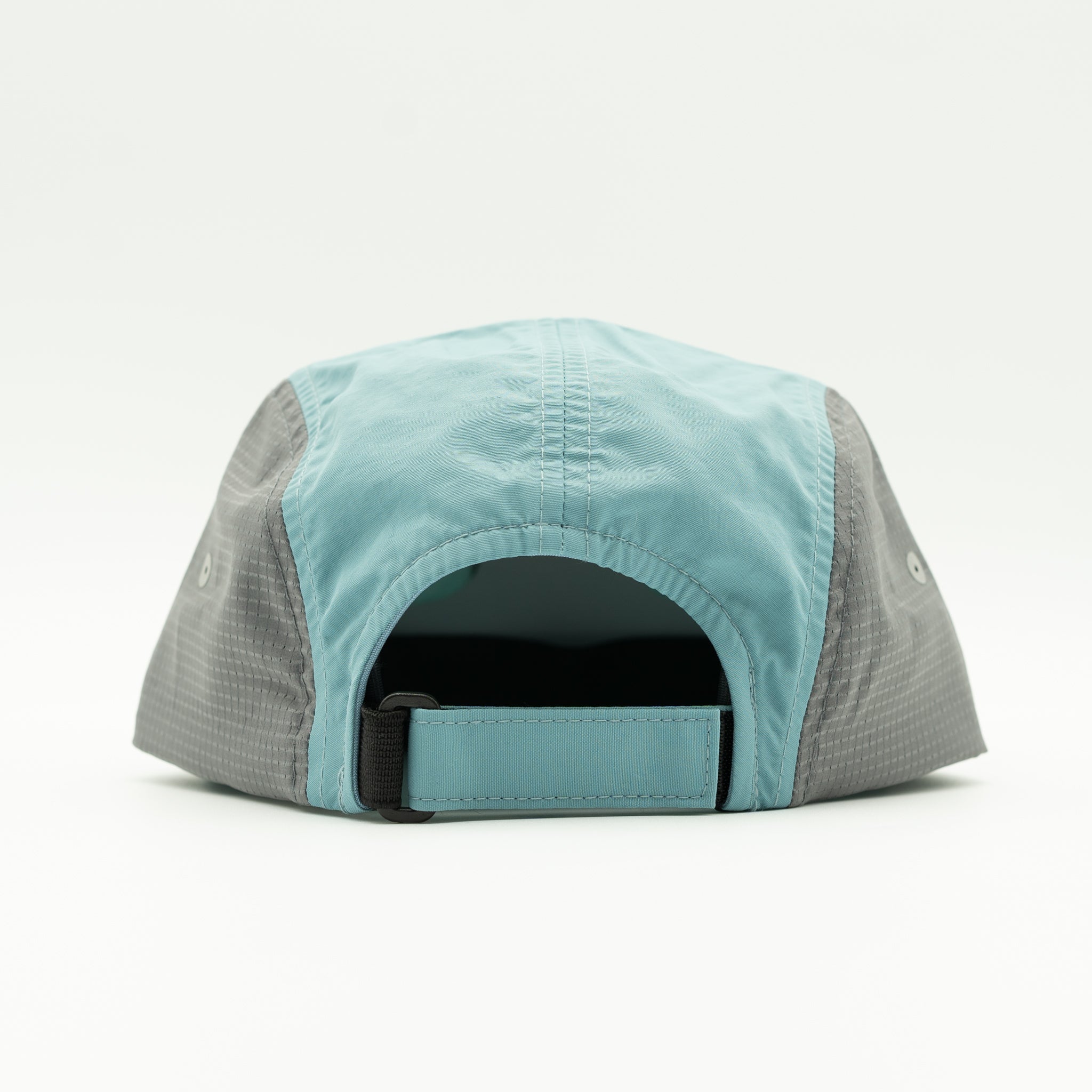 The back view of a baseball cap in light blue and gray, featuring a light blue crown, gray side panels, and an adjustable light blue strap.
Color: Smoke Blue/Charcoal