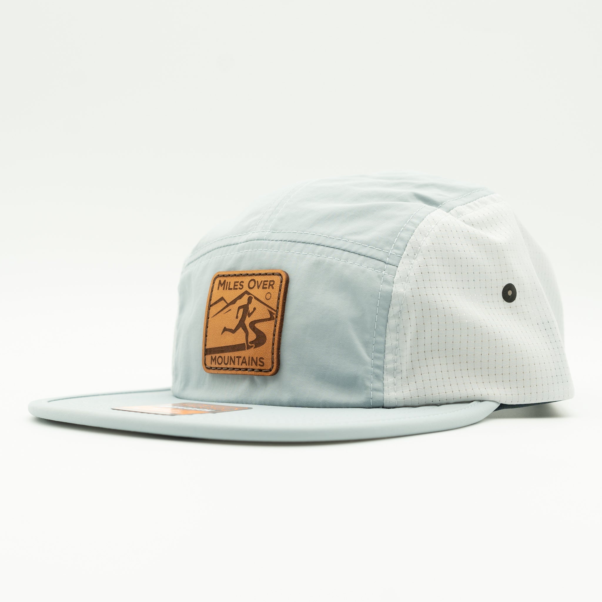 A light blue and white 5-panel cap with a brown leather patch on the front that reads 'Miles Over Mountains'.
Color: Grey/Glacier Grey