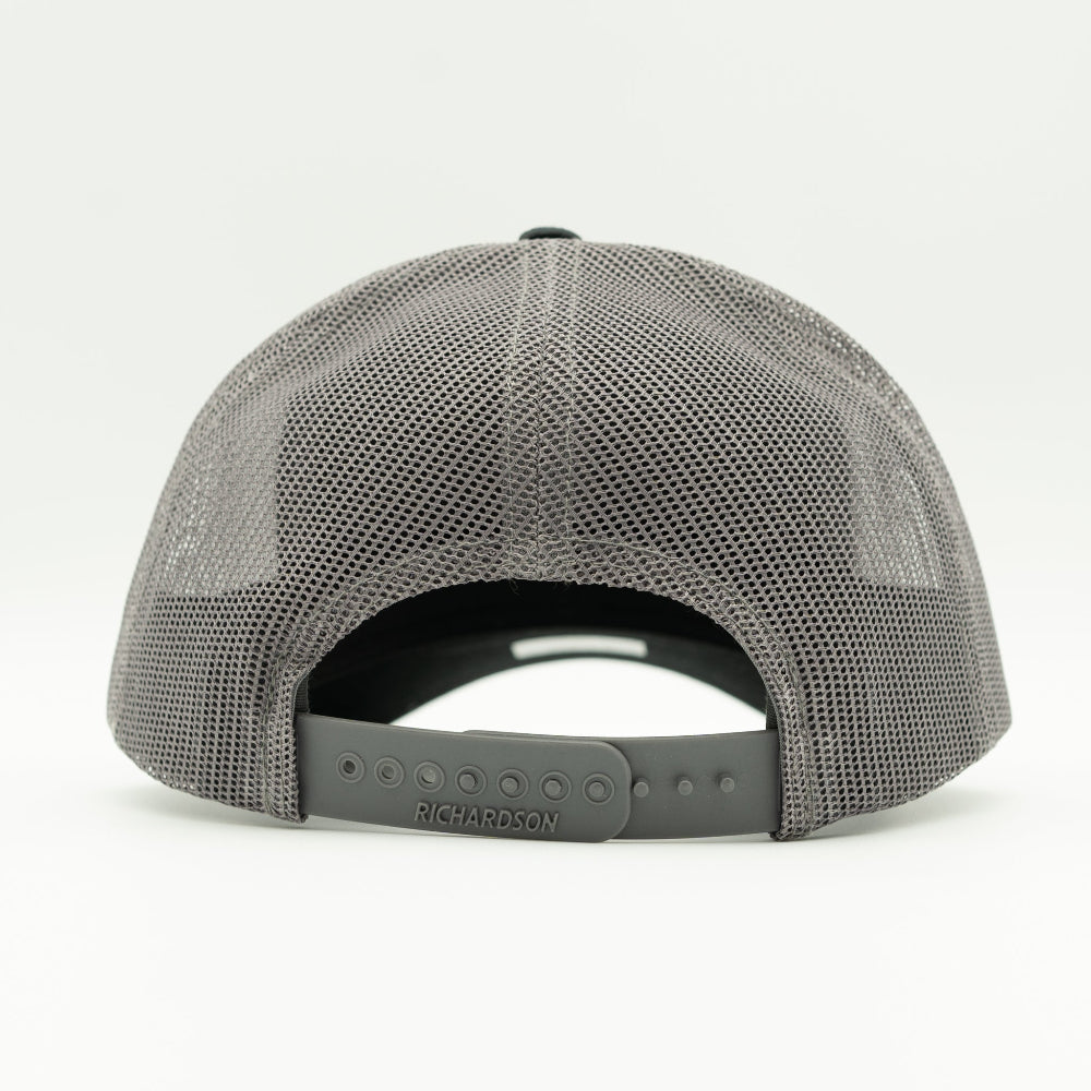 Back of Black Charcoal Blossom leather patch Richardson 115 trucker hat with breathable mesh and snapback fit.

Color: Black/Charcoal