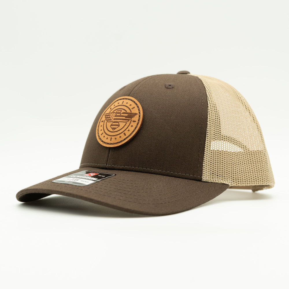 Side view of brown and khaki Richardson 115 low profile trucker hat with American Eagle leather patch, showing brown front panel, curved bill, and light khaki mesh back.

Color: Brown/Khaki