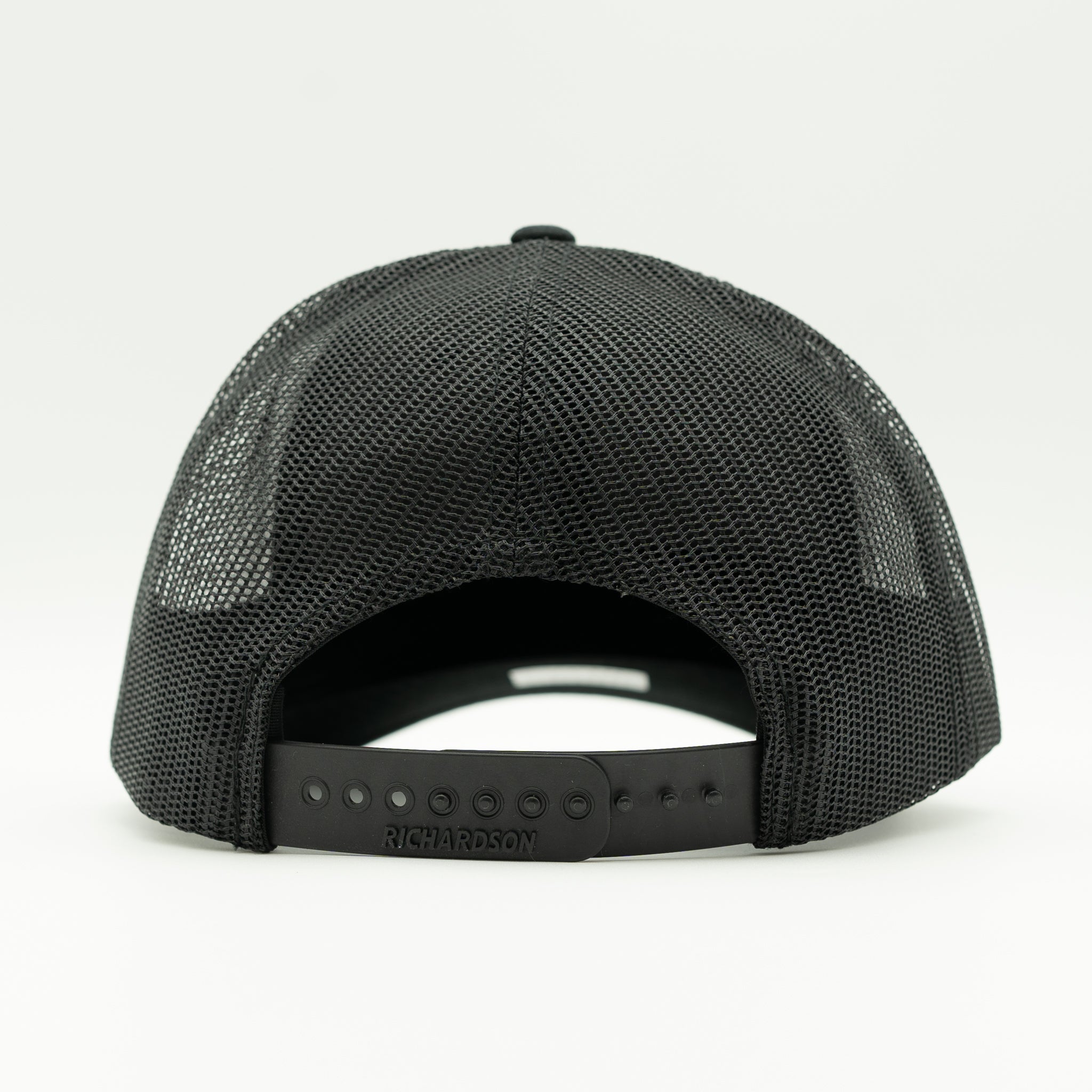 The back view of a black mesh trucker hat with an adjustable snapback closure, shown on a clean white background.

Color: Solid Black