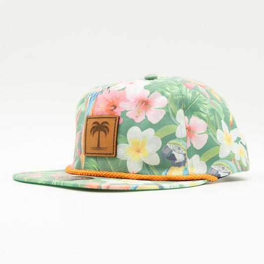 Side view of the Island Breeze Hat in Hawaiian Rainforest, highlighting the unique rainforest-themed print, structured profile, and classic rope detail. The hat includes a genuine leather patch with a palm tree engraving and an adjustable leather strap for a custom fit.