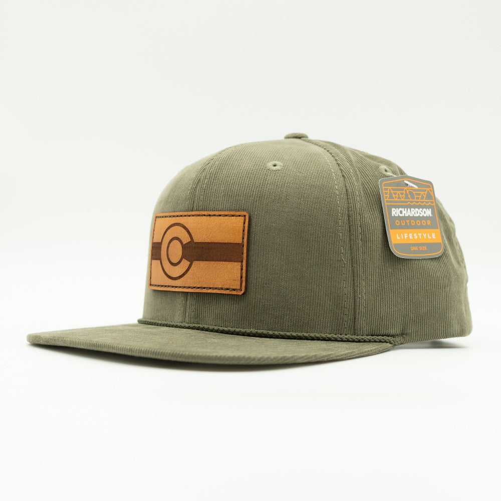 Side view of olive Richardson 253 corduroy flat bill hat with brown Colorado leather patch, high crown and snapback.