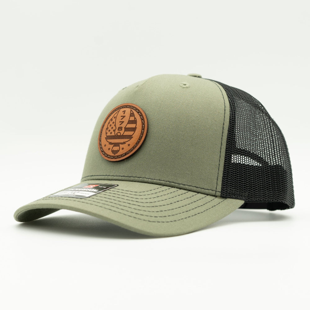 Custom Loden/black Richardson Leather Patch hat. Our custom designed leather patch is laser engraved and sewn onto a Richardson 112 Hat. We use full-grain, veg tanned leather. Our custom leather patches are handmade and designed in Colorado, USA.