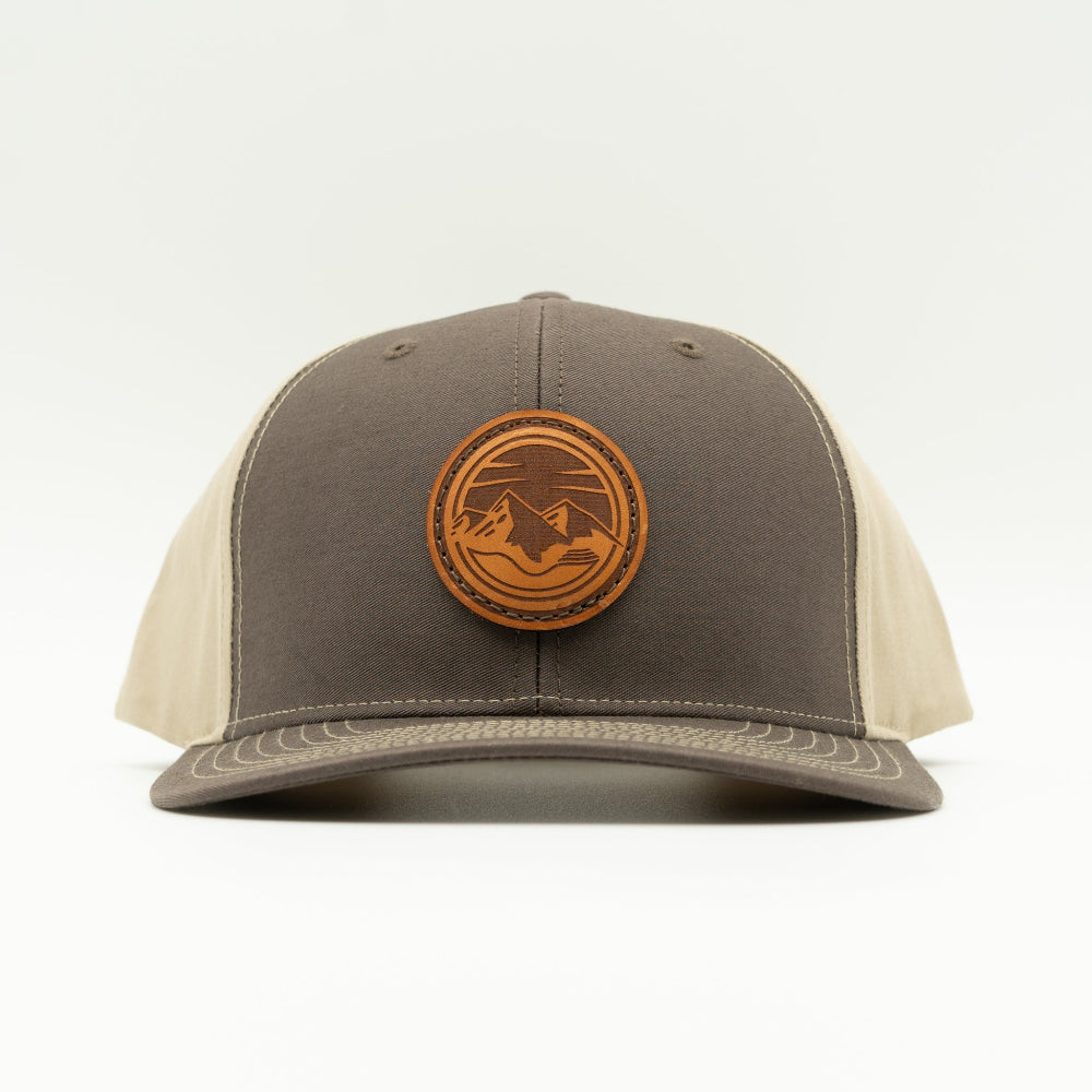 Front view of the Mountain Lake leather patch hat on Richardson 312 in Brown/Khaki, featuring a six-panel, mid-profile design with a real leather patch showcasing the Mountain Lake design. Perfect for mountain man apparel lovers.