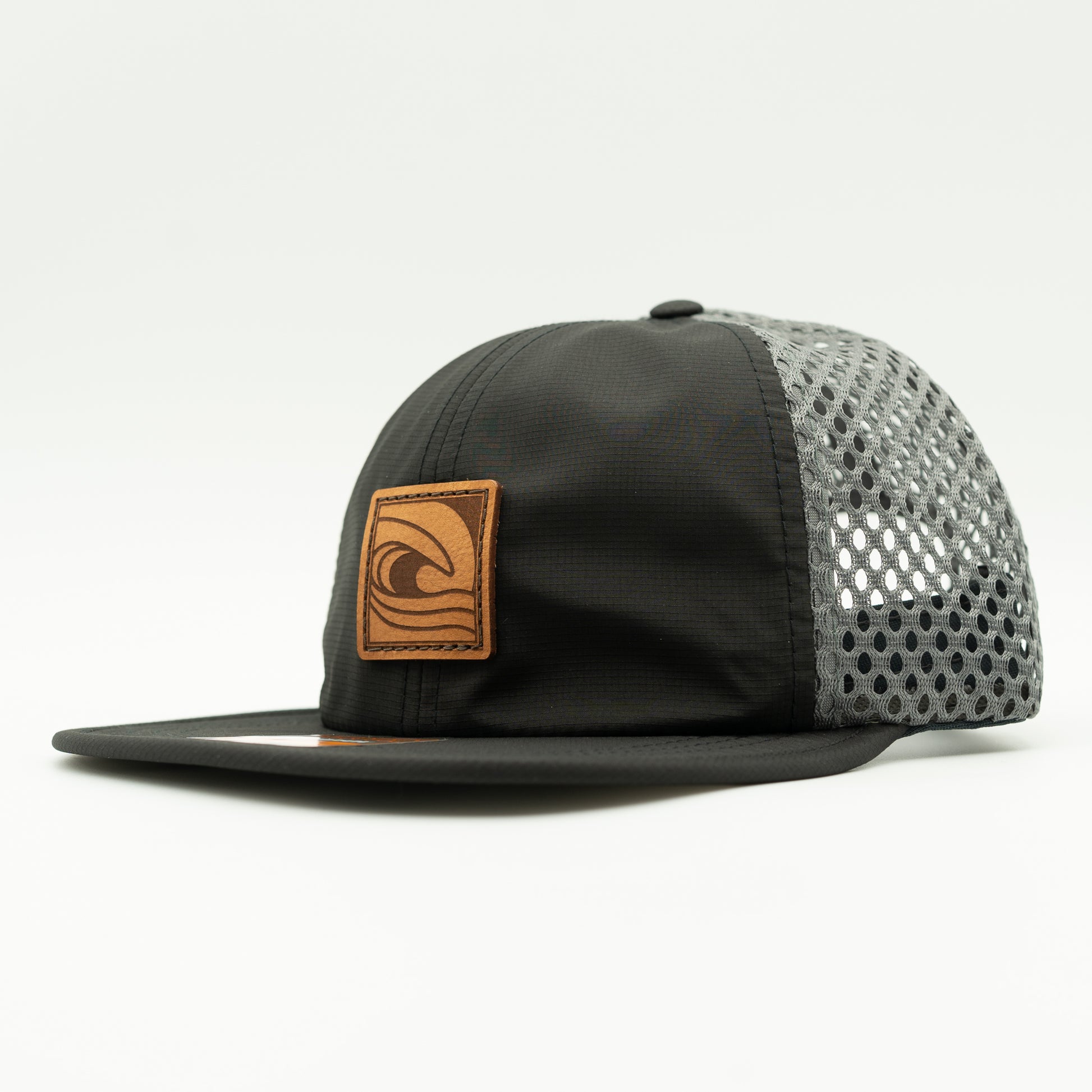 Side view of the Ocean Swell Hat by Outer Wings in Black/Charcoal, highlighting the unstructured build, wide-set mesh back, and adjustable backstrap. A lightweight and breathable performance hat ideal for all adventures.