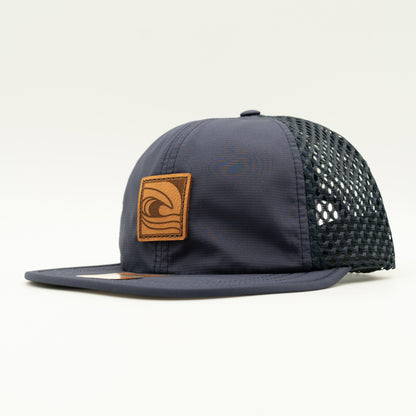 Side view of the Ocean Swell Hat by Outer Wings in Navy/Navy, highlighting the breathable mesh back, flex packable visor, and quick adjust webbing backstrap. A performance hat that combines style and function.