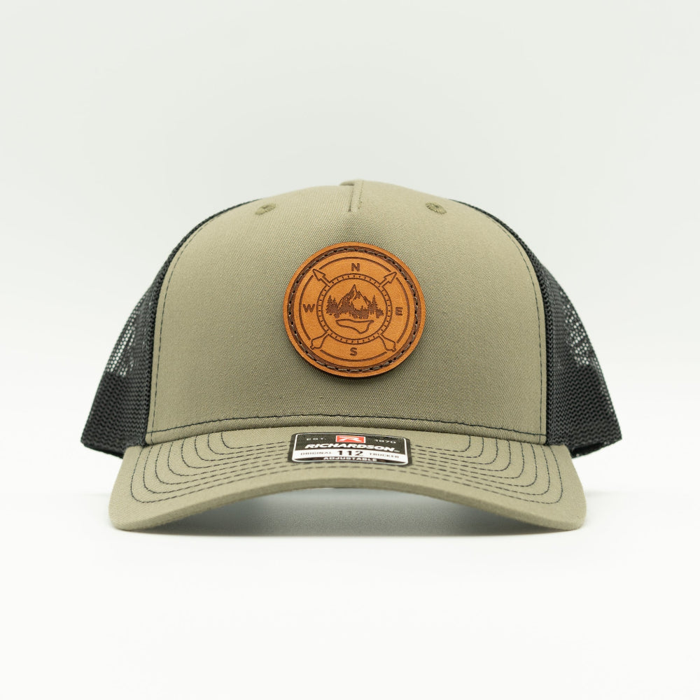 Front view of the Outdoor Compass Leather Patch Hat by Outer Wings in Loden/Black, highlighting the structured profile, breathable mesh back, and adjustable SnapBack closure. A rugged and stylish performance hat for all outdoor activities.